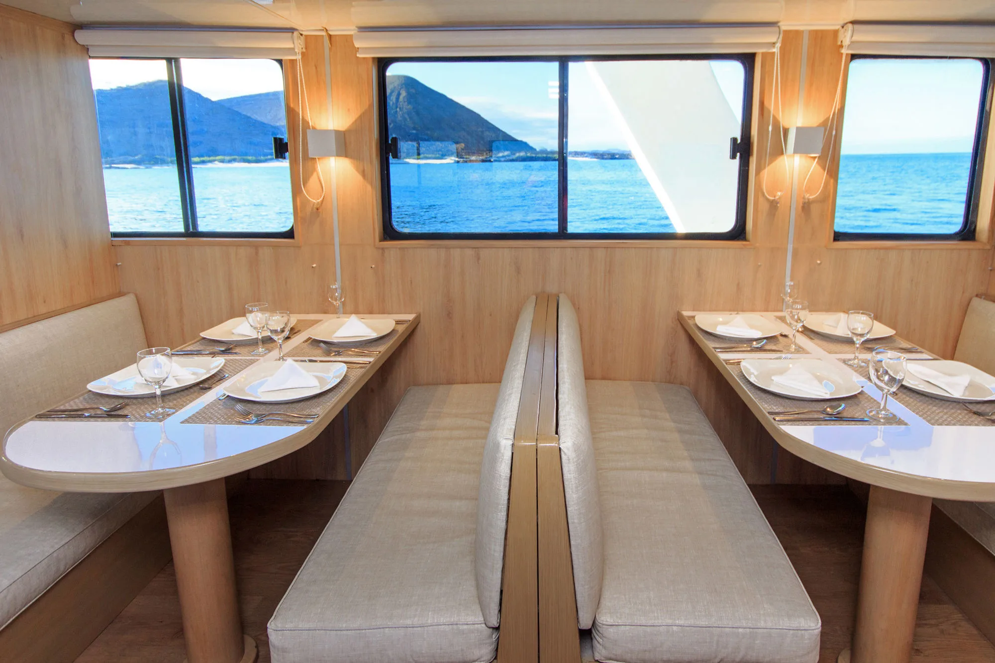 Dining tables on Aqua by windows looking out to sea