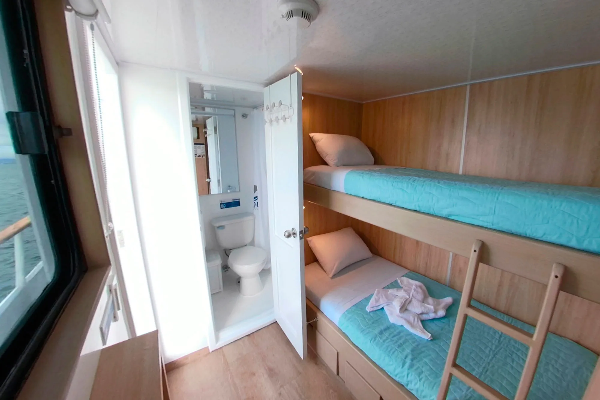 Upper deck twin cabin on Aqua — private bathroom behind the door