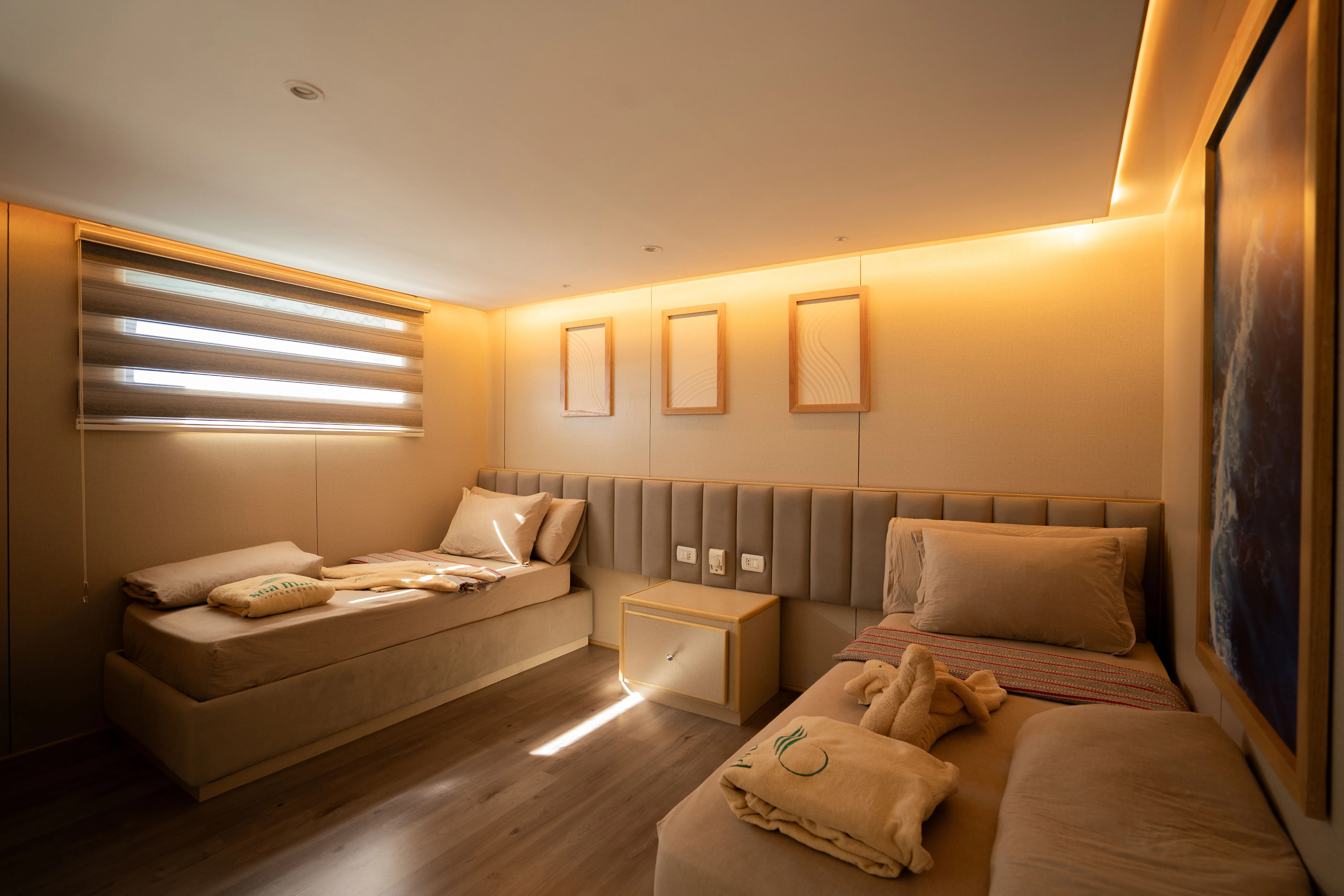 Standard cabin on Avo — beds along both sides and a bedside cabinet