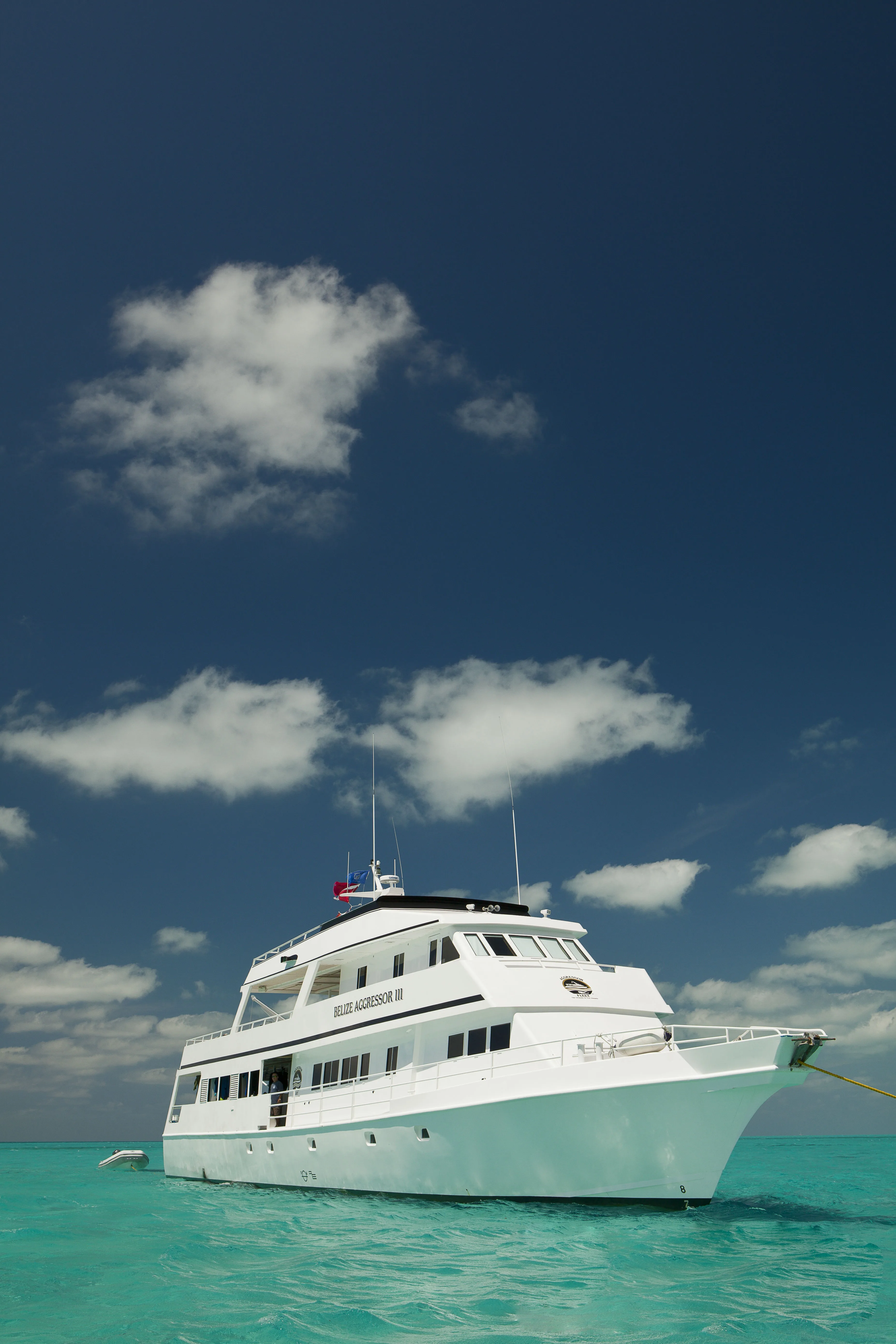 Belize Aggressor III seen from the bow over the shallows of an atoll