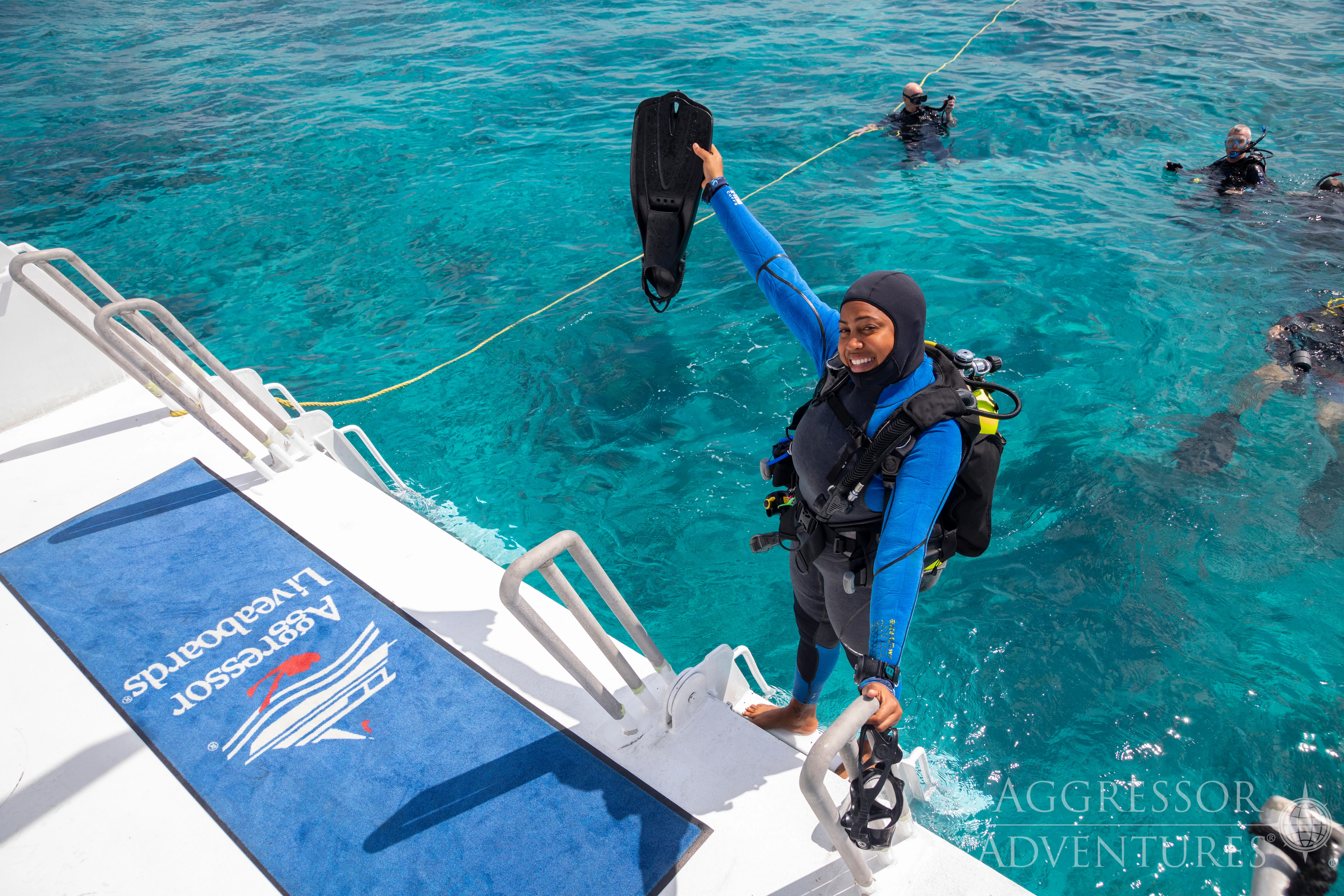 A diver entering the water from the platform of Belize Aggressor III