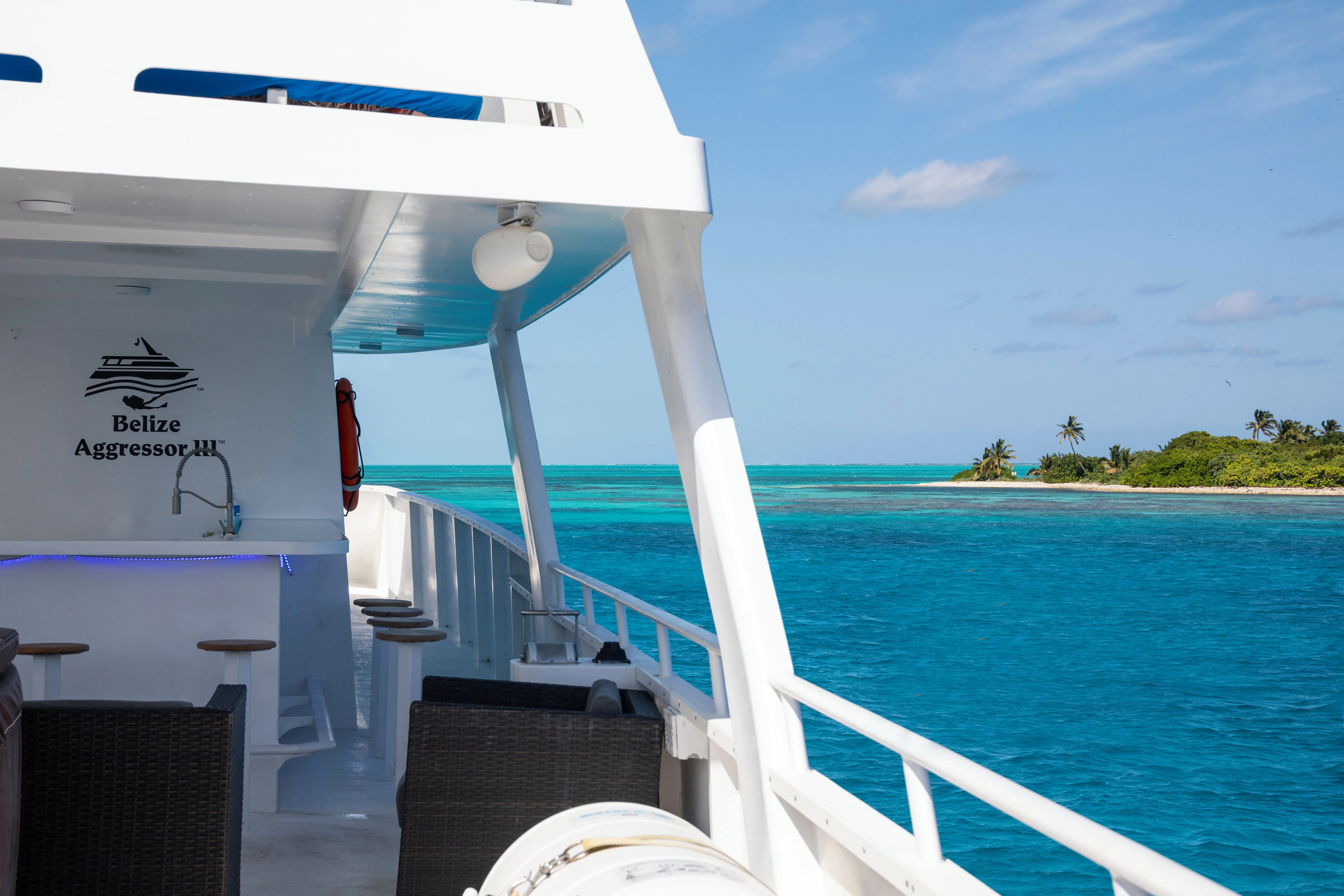 Shaded cocktail deck of Belize Aggressor III looking towards an island