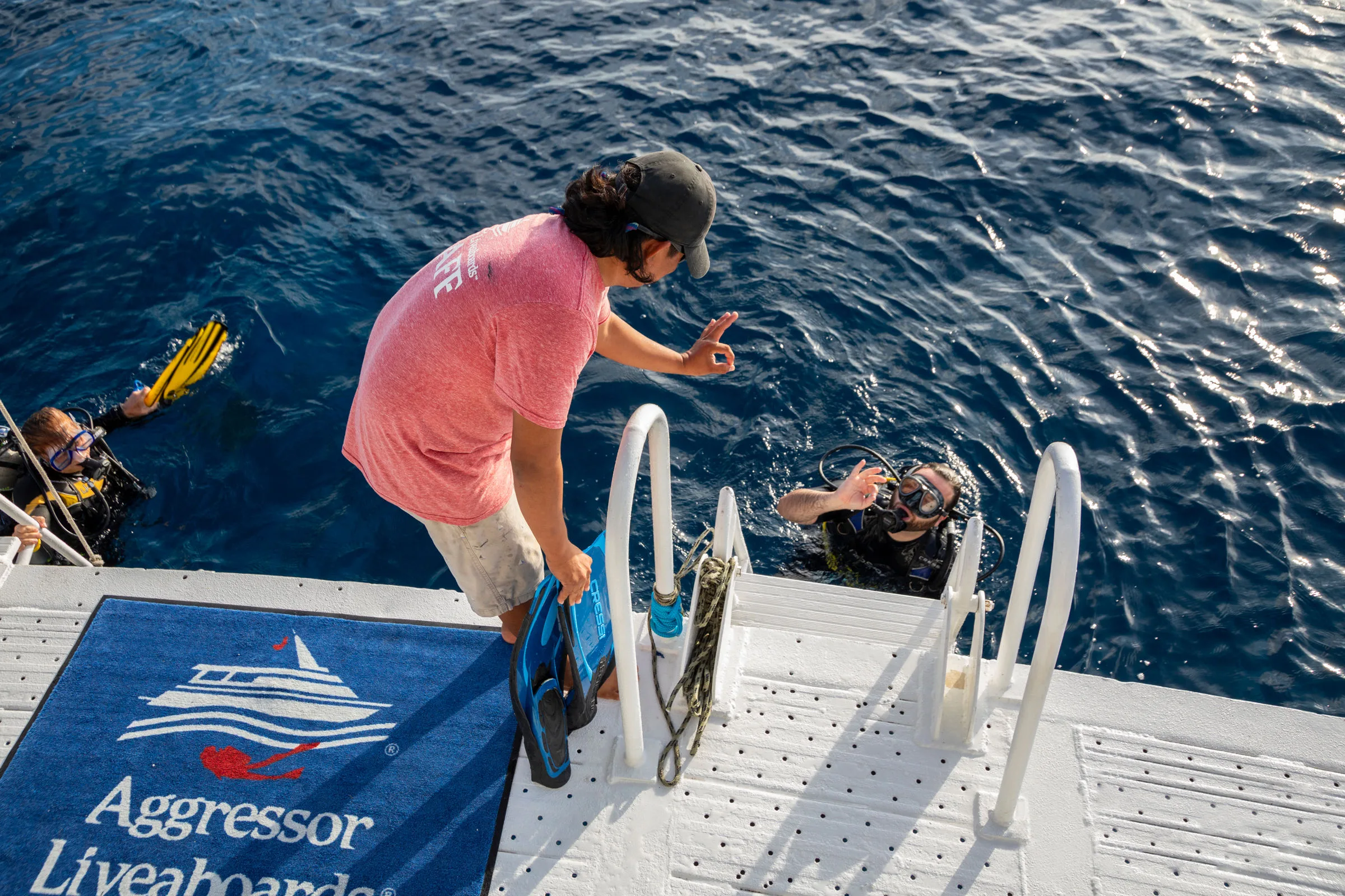 Divers dropping into the water from the stern platform
