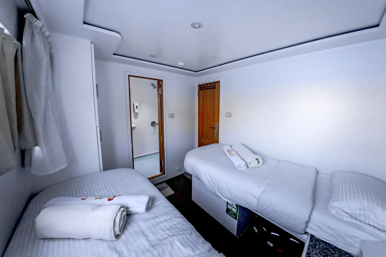 Bella 3 dive-deck twin cabin — bathroom door and beds along the sides