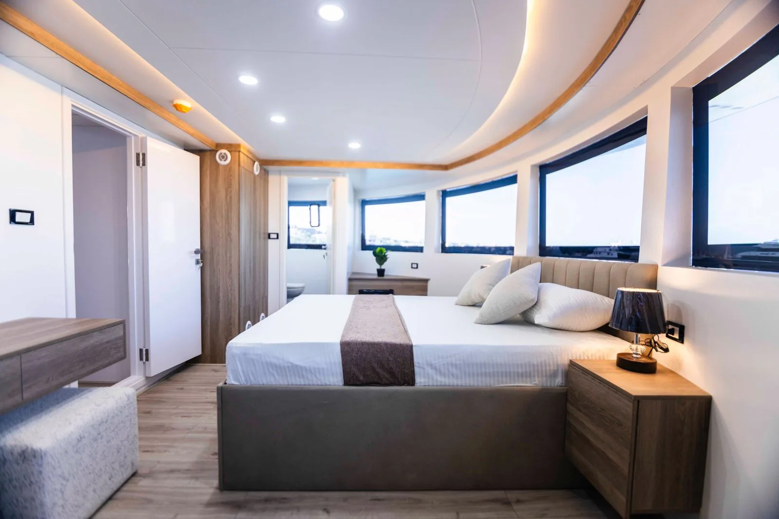 Интерьер Master Suite — светлое дерево, изголовье в рубчик и вид на марину из окон