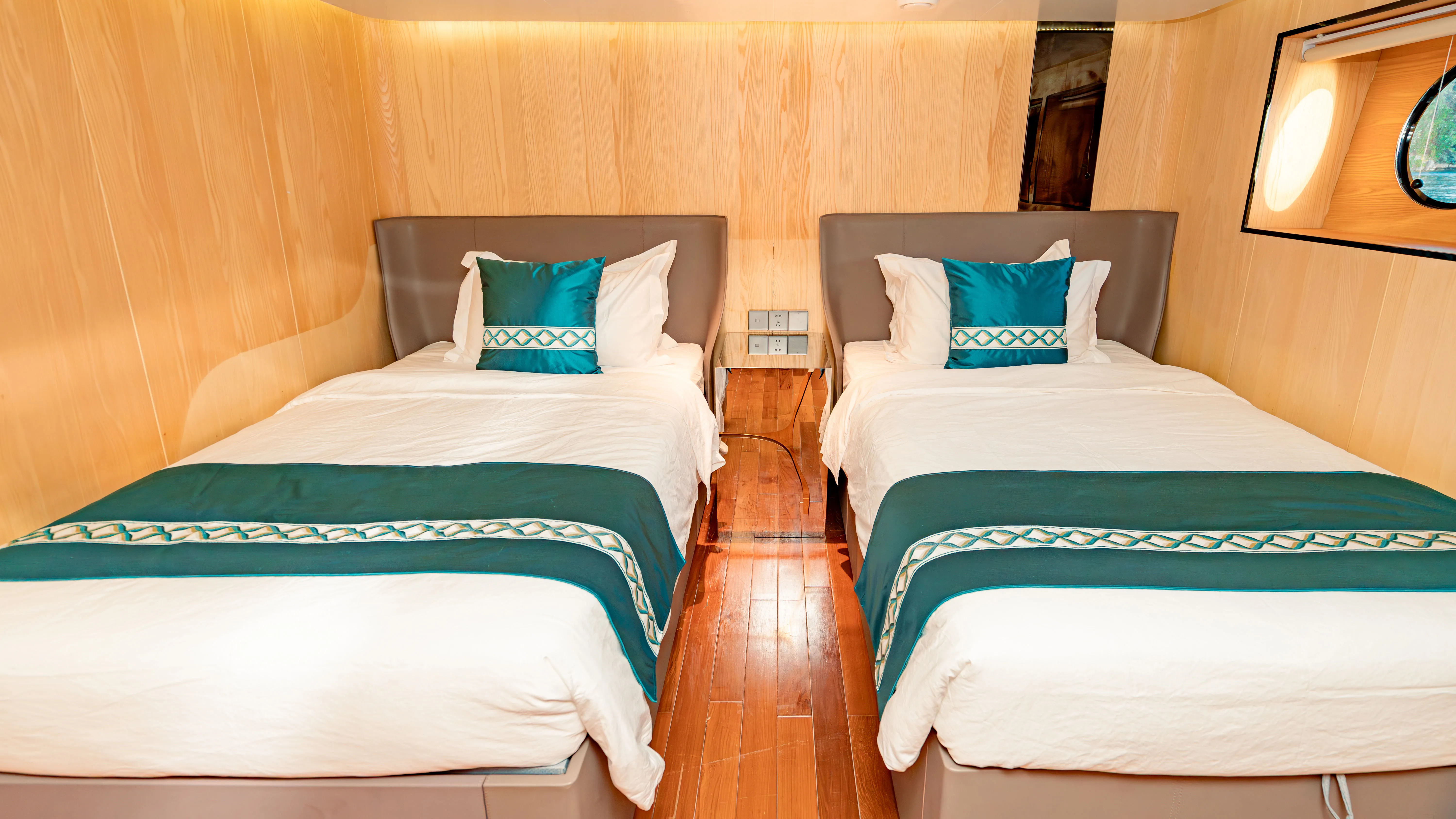 Deluxe Twin cabin on Black Pearl — two single beds with turquoise linen