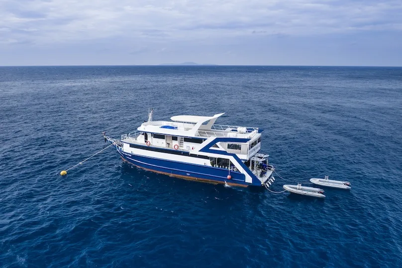 Blue Dolphin at sea with two inflatable dinghies alongside