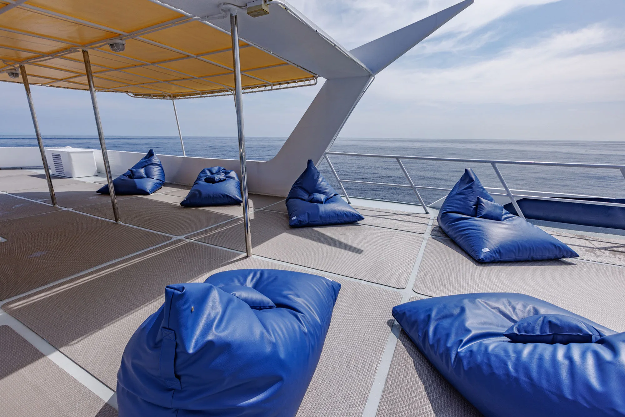 Shaded sun deck with blue cushions for lounging