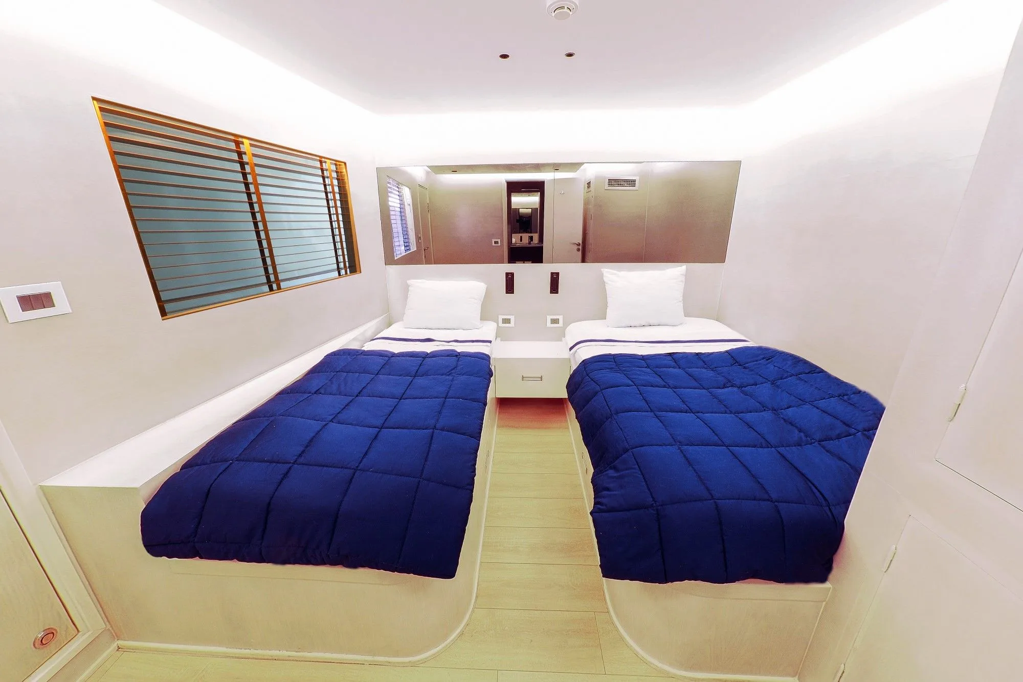 Double cabin on the main deck of Blue Force Three — two beds and window blinds