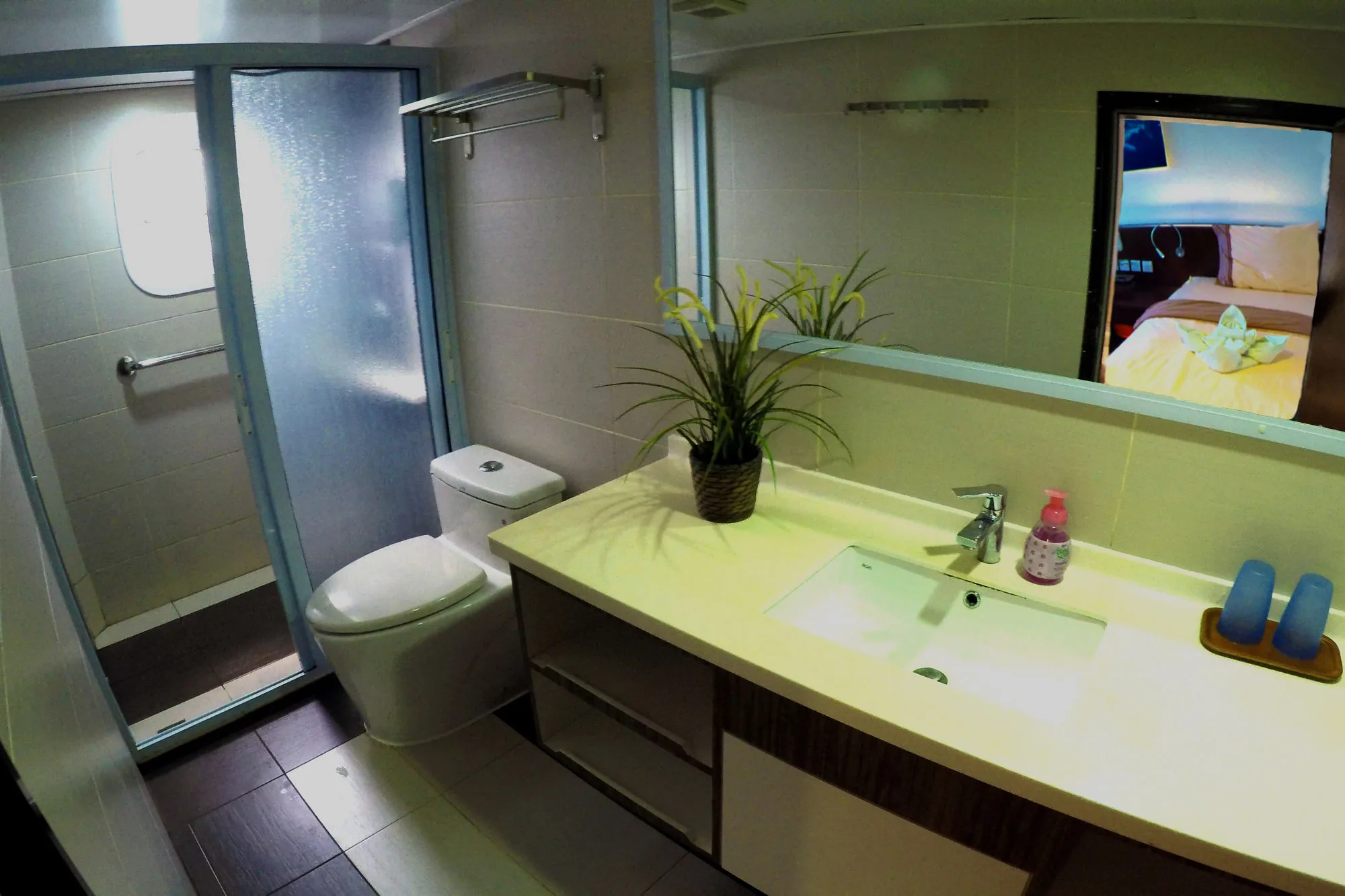 Main deck bathroom — shower cubicle, basin on a wide counter and a full-width mirror