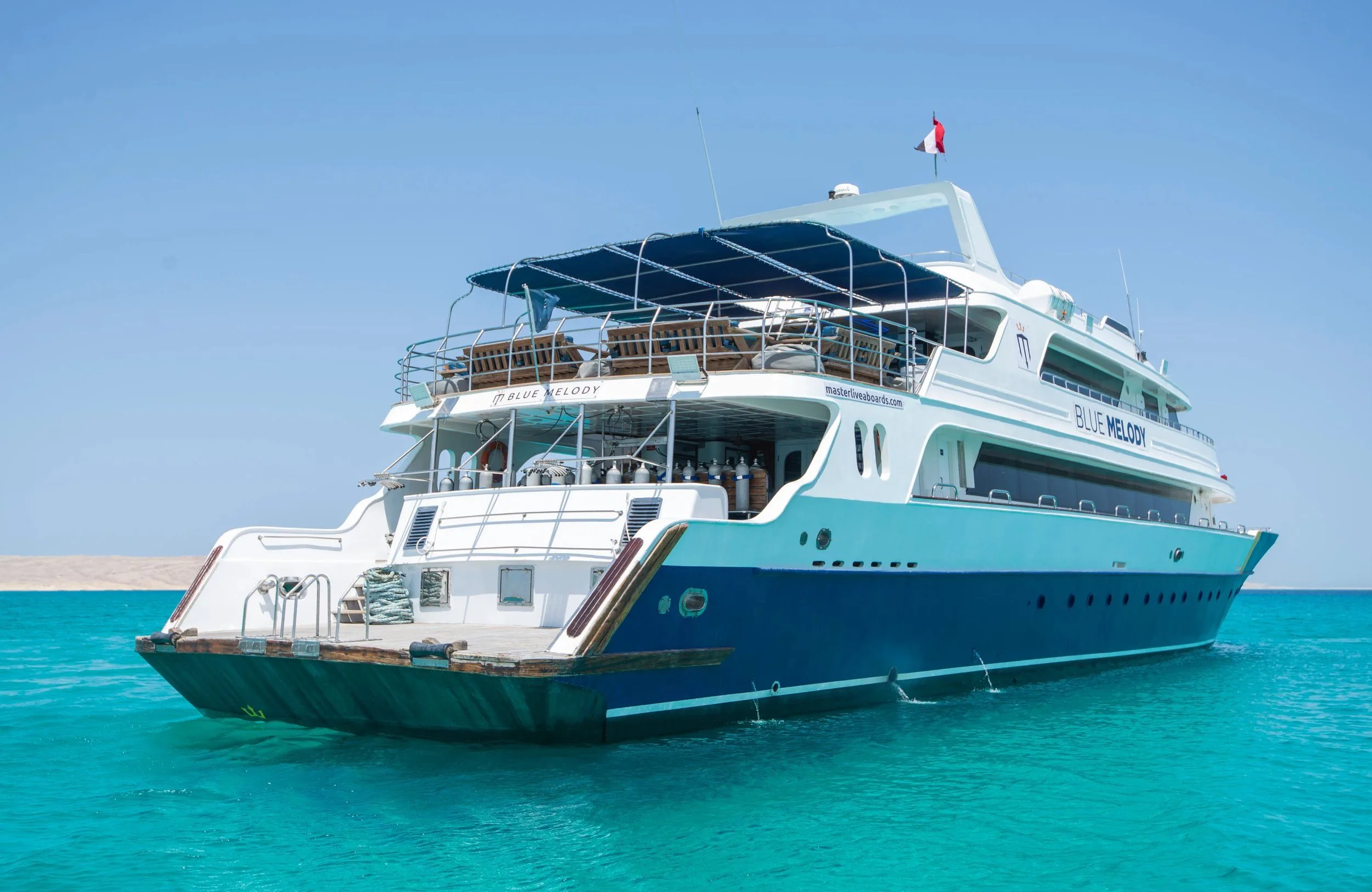 Кормовая четверть Blue Melody — солнечная палуба под тентом и трап к воде