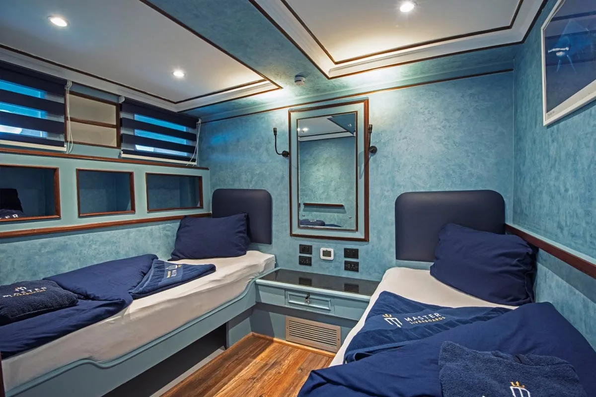 Каюта Classic Twin на нижней палубе Blue Melody — две односпальные кровати, зеркало и полки над изголовьями