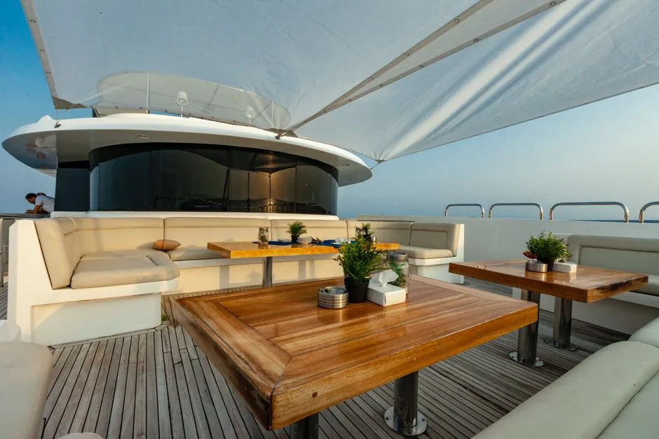 Shaded bow lounge with soft seating and teak tables
