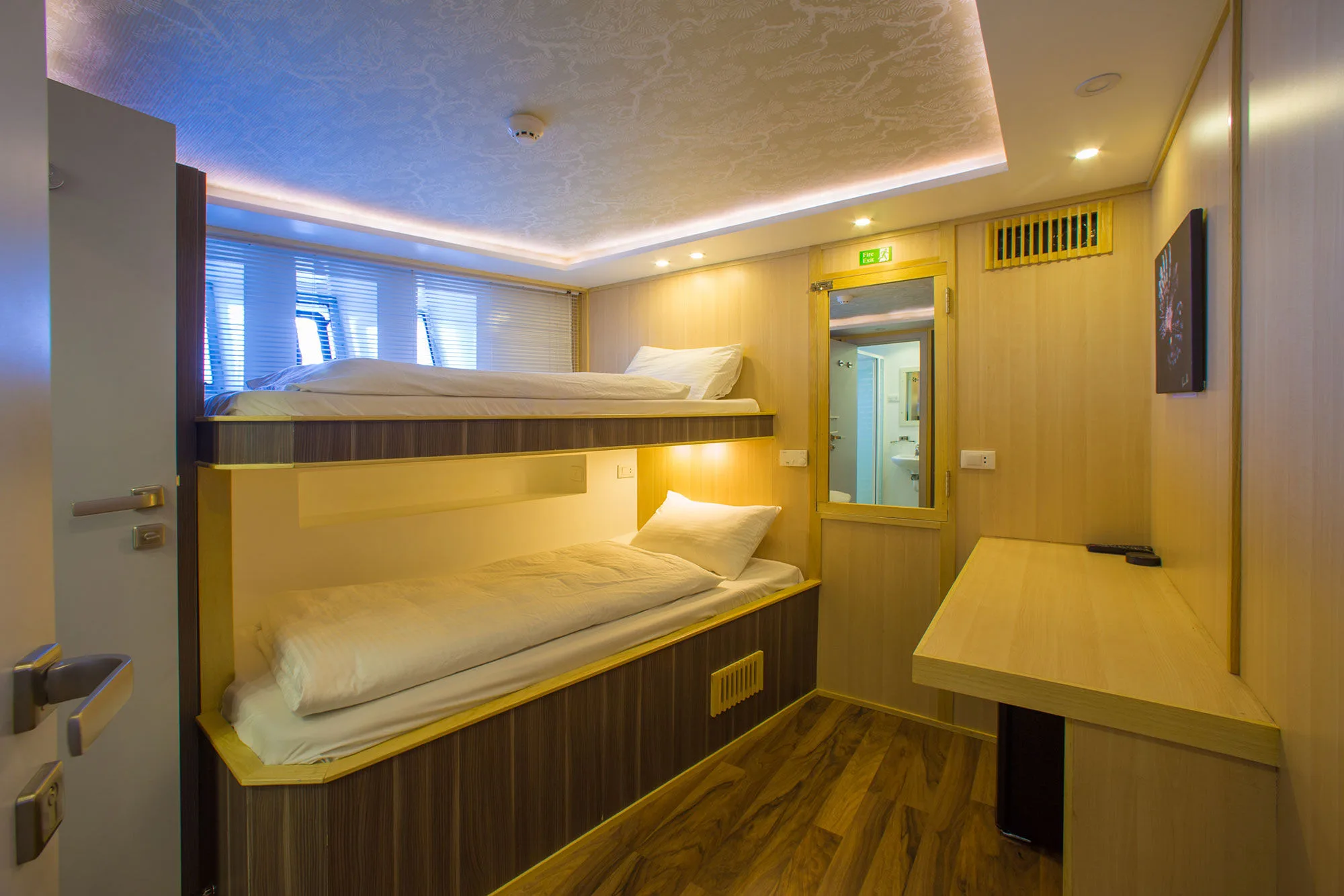 Bow cabin — beds one above the other and a desk