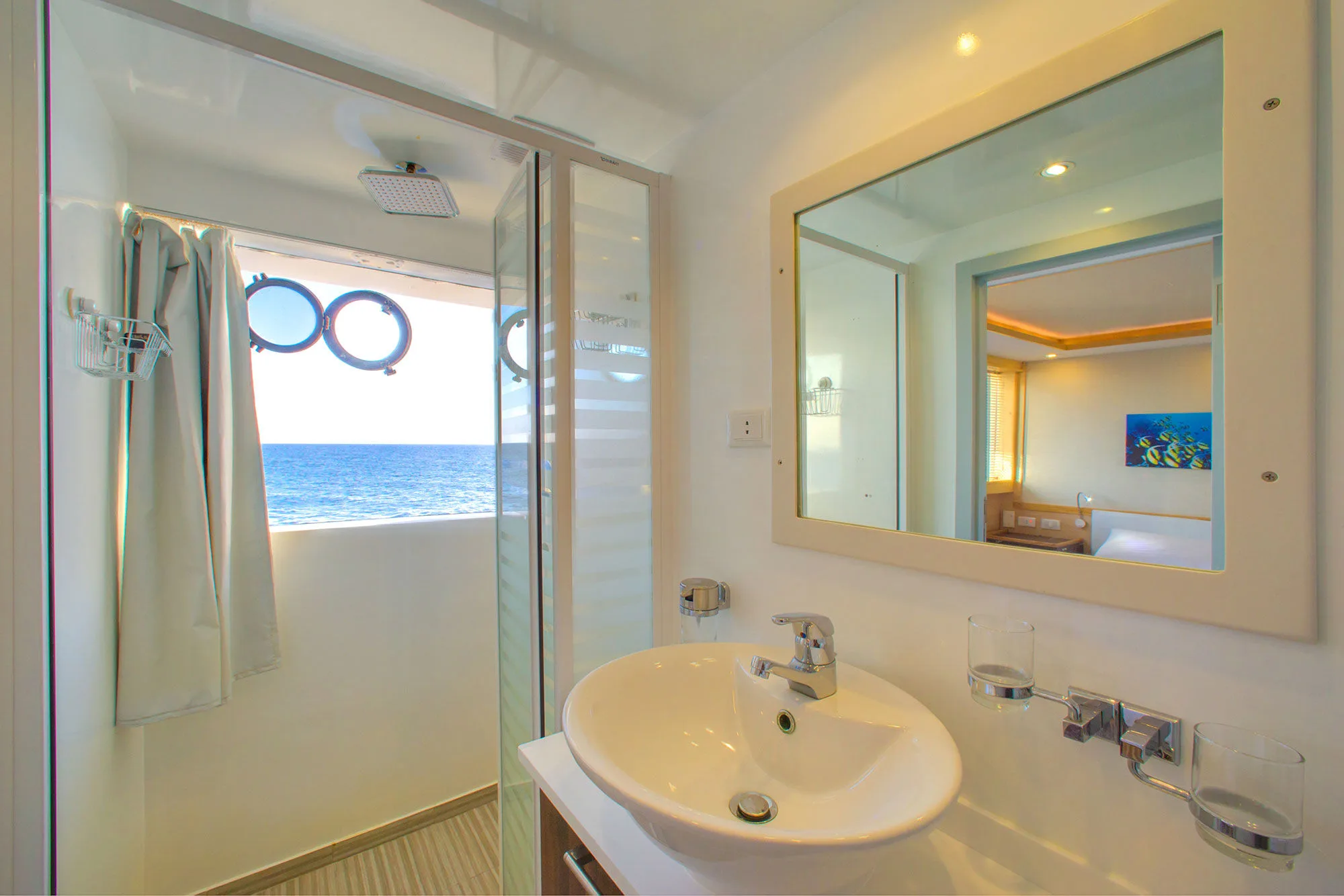 Sea View cabin bathroom — shower cubicle and a sea view through the porthole