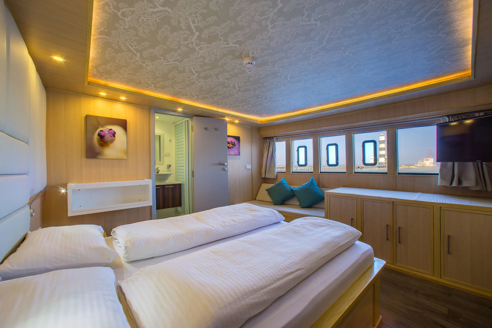 Master suite — double bed and a sofa by the portholes
