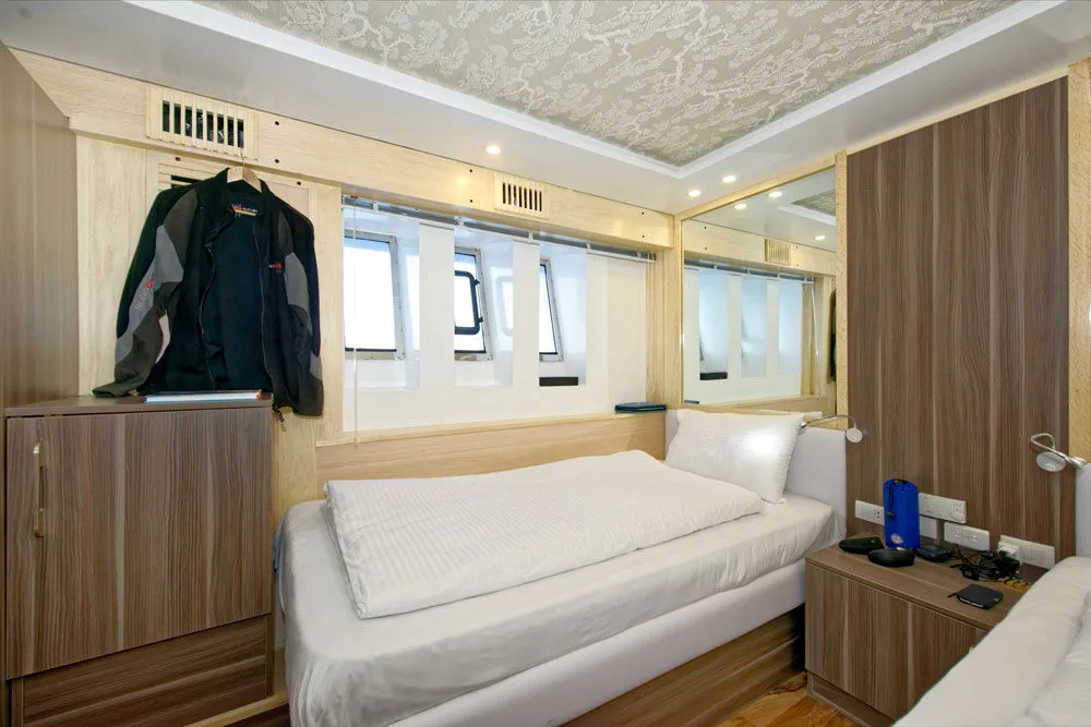 Lower deck cabin — bed under the windows and space for a wetsuit