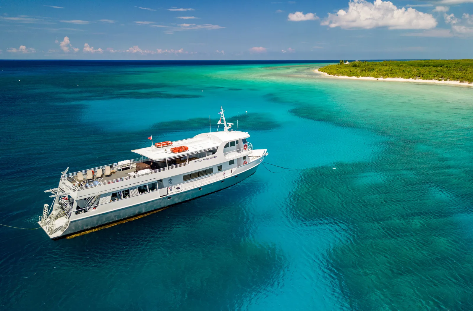 Aerial view of Cayman Aggressor IV over shallow reef water