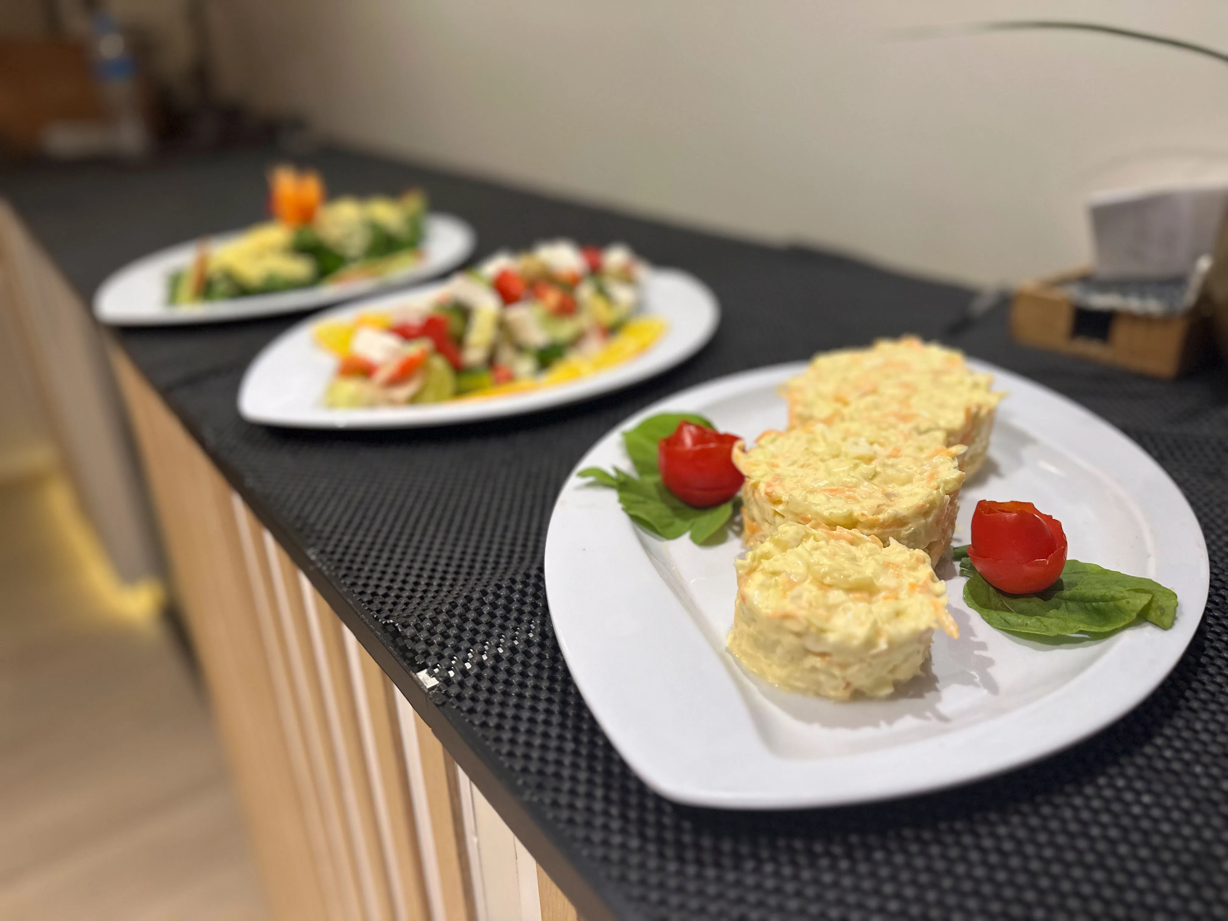 Тарелки с салатами и закусками на барной стойке