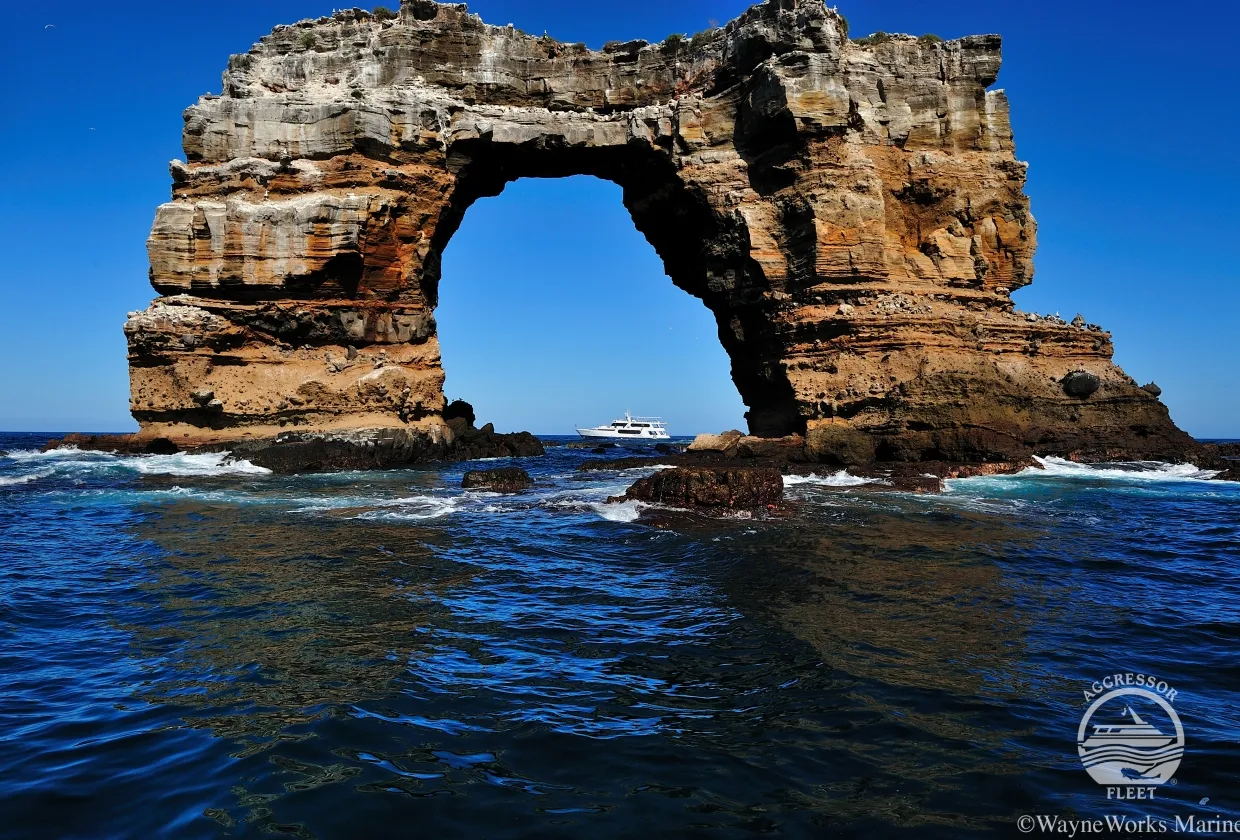 Darwin's Arch with the yacht passing beneath it
