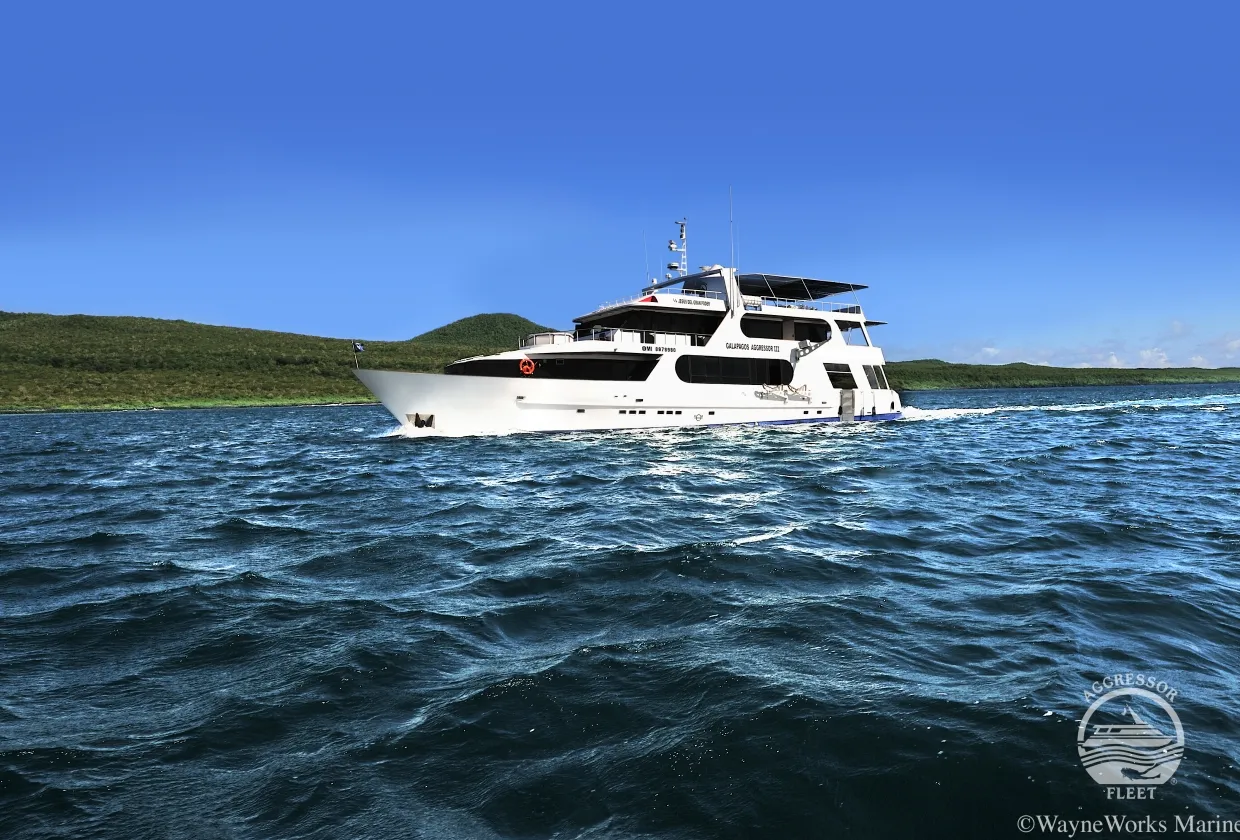 Galapagos Aggressor III under way past a green shoreline