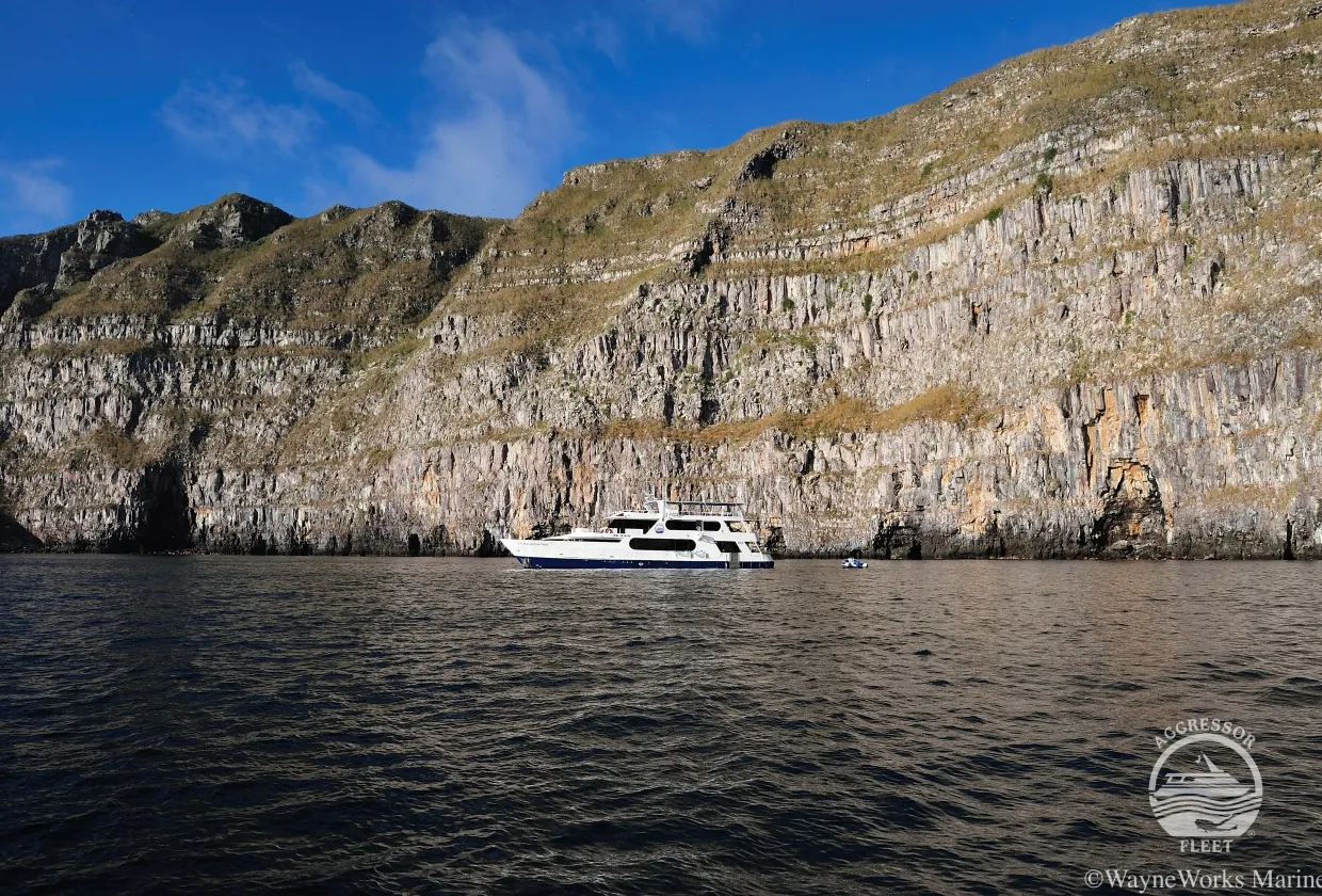 Galapagos Aggressor III against a steep island wall