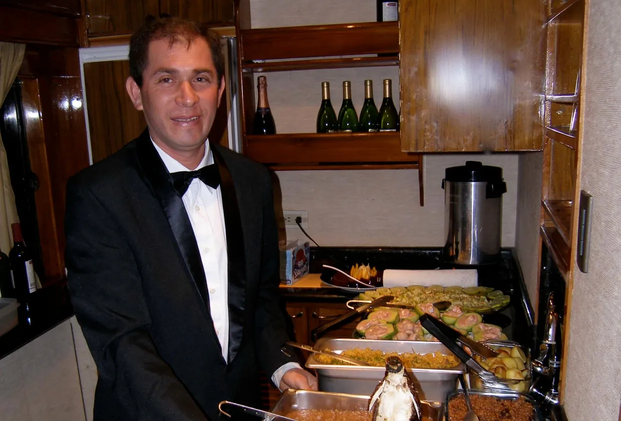 Steward serving hot dishes in the galley of Galapagos Aggressor III