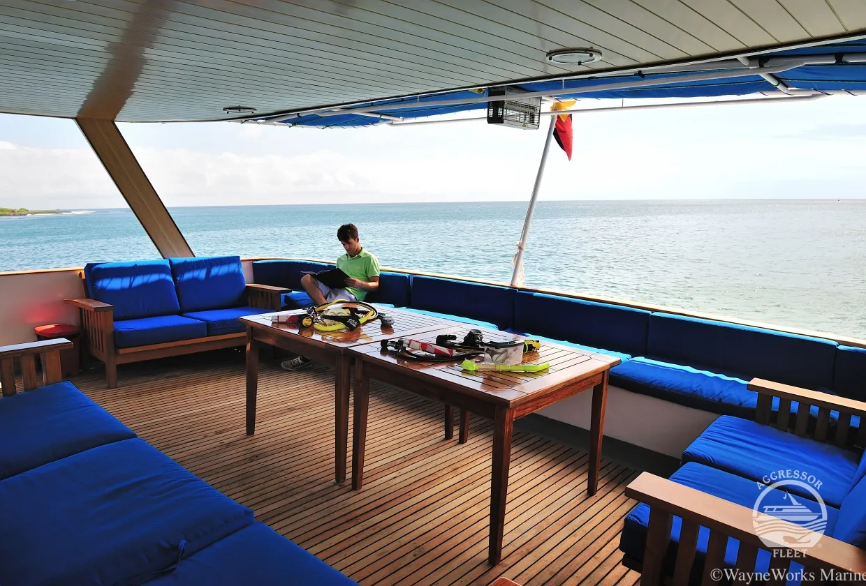 Open-air lounge on the aft deck with cushioned seating