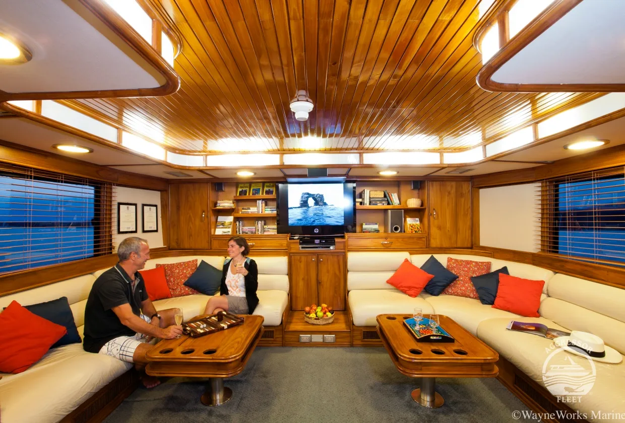 Saloon of Galapagos Aggressor III with wood panelling and a TV