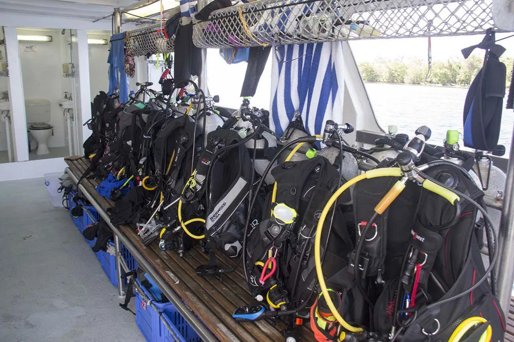 Scuba gear on the dive deck racks of Galapagos Master