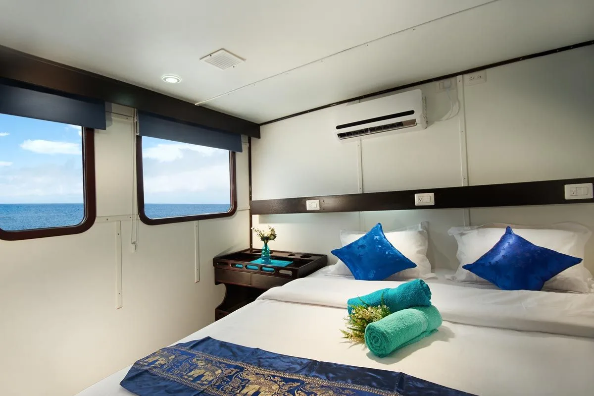 Upper deck cabin on Galapagos Master with a double bed and panoramic windows
