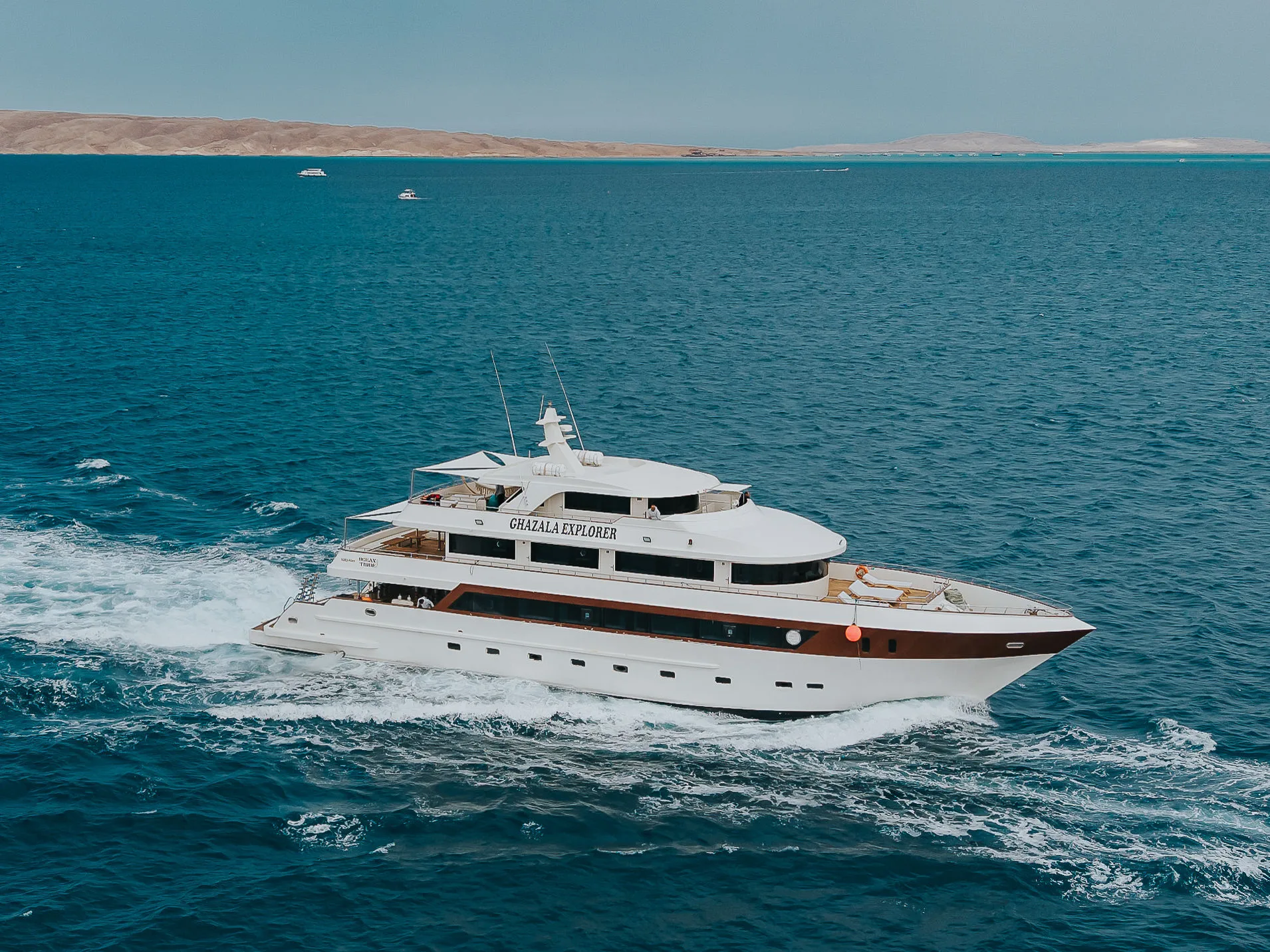 Ghazala Explorer на ходу в Красном море, вид с дрона — белый корпус с рыжей полосой