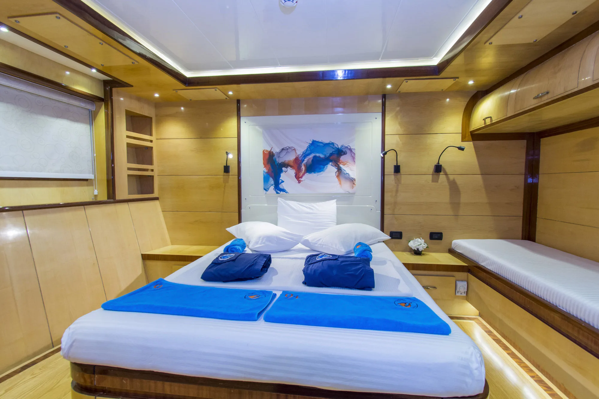 Двуспальная каюта основной палубы Golden Dolphin IV — кровать и картина над изголовьем