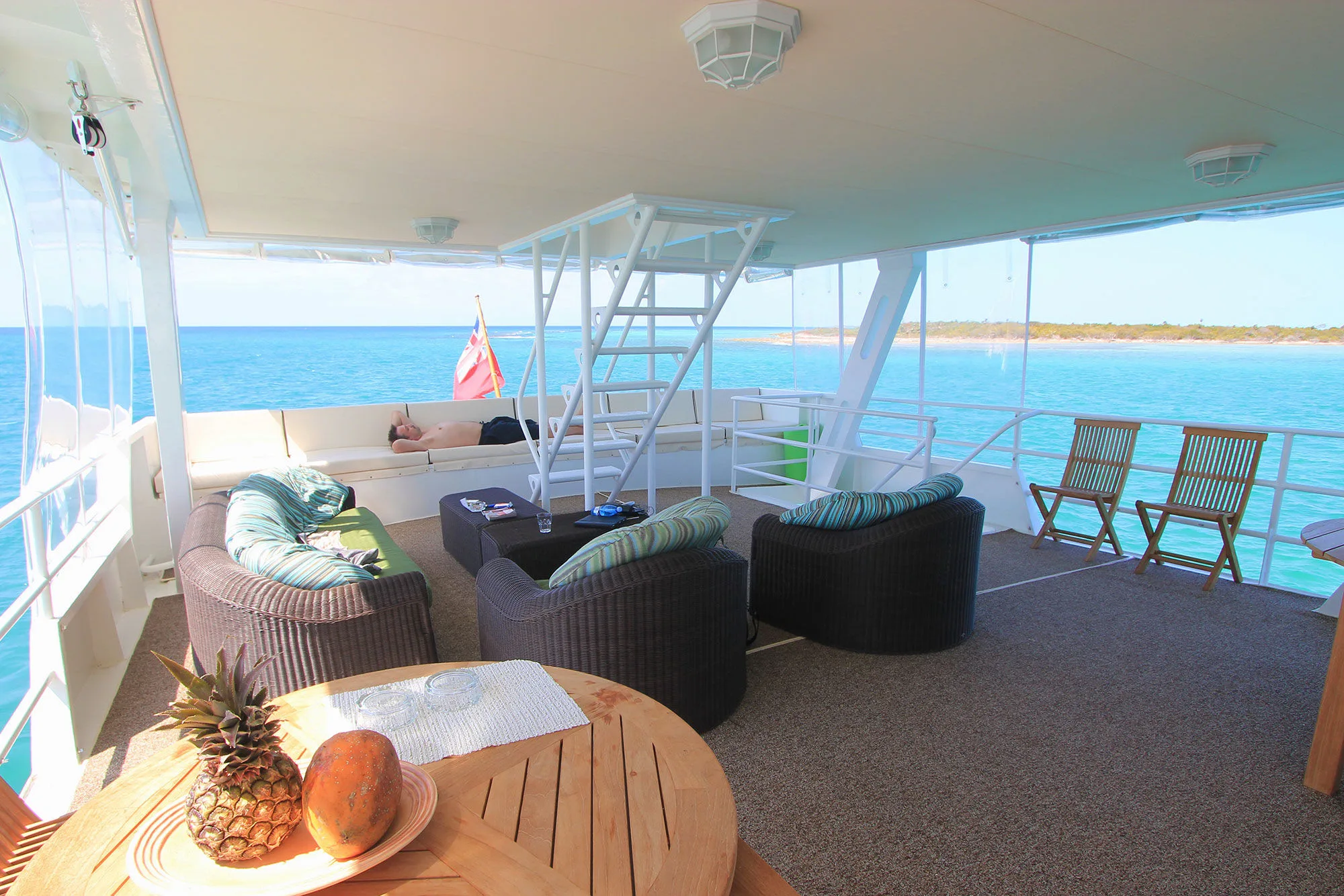 Shaded aft lounge with soft seating and a view over the water