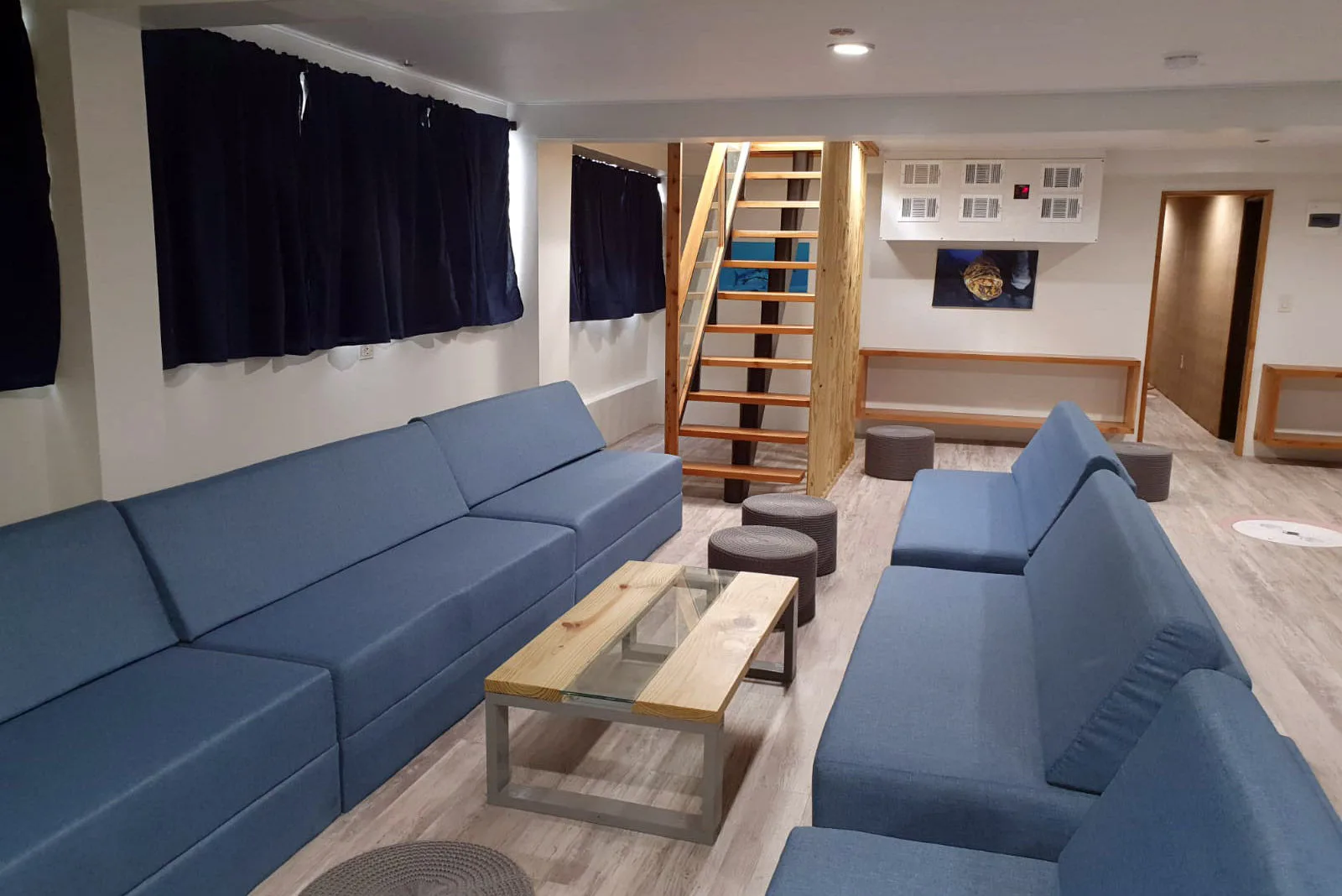 Indoor lounge with cushioned sofas along panoramic windows