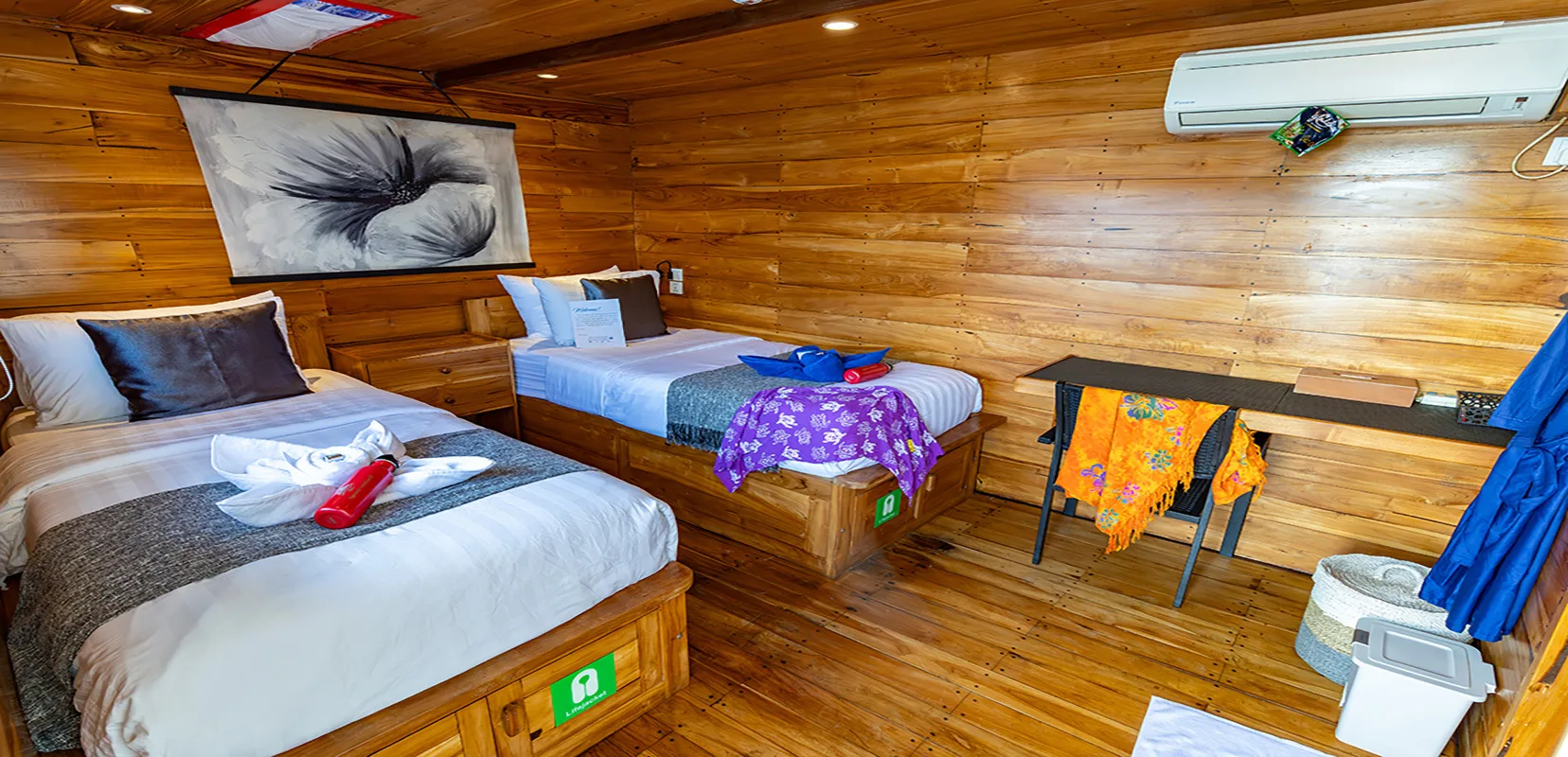 Master Stateroom on Komodo Aggressor — two single beds, its own air conditioning control and a rail for gear