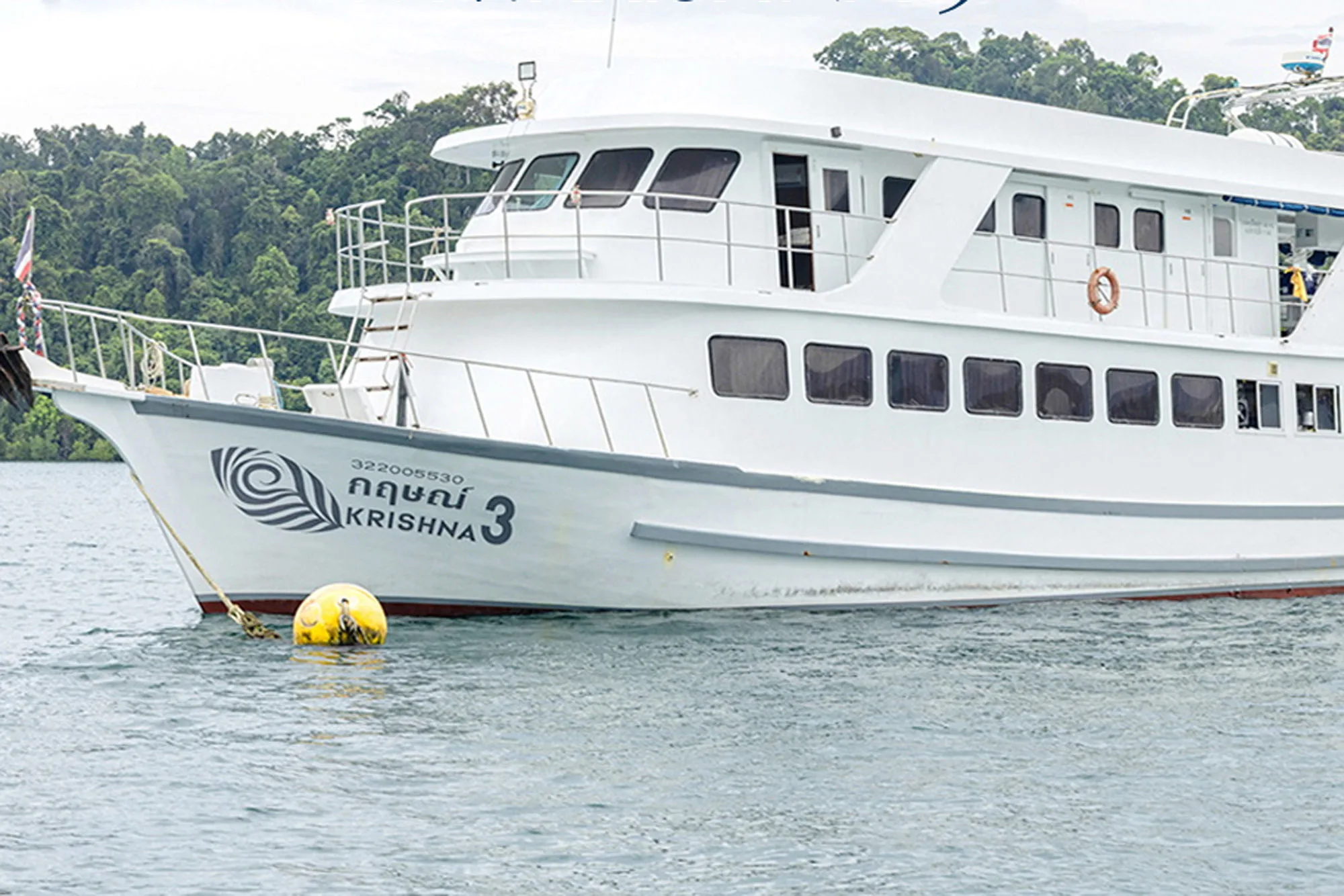 Krishna 3 at anchor — white hull with the vessel's name on the bow