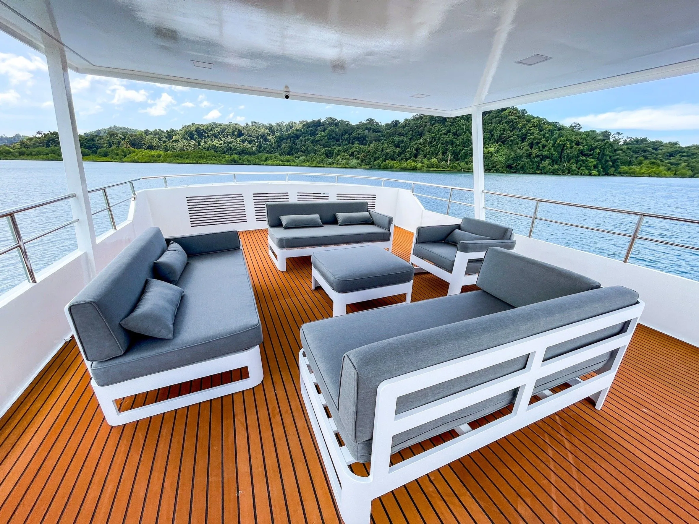 Covered lounge area with soft sofas on the deck of Mandarin Queen 9
