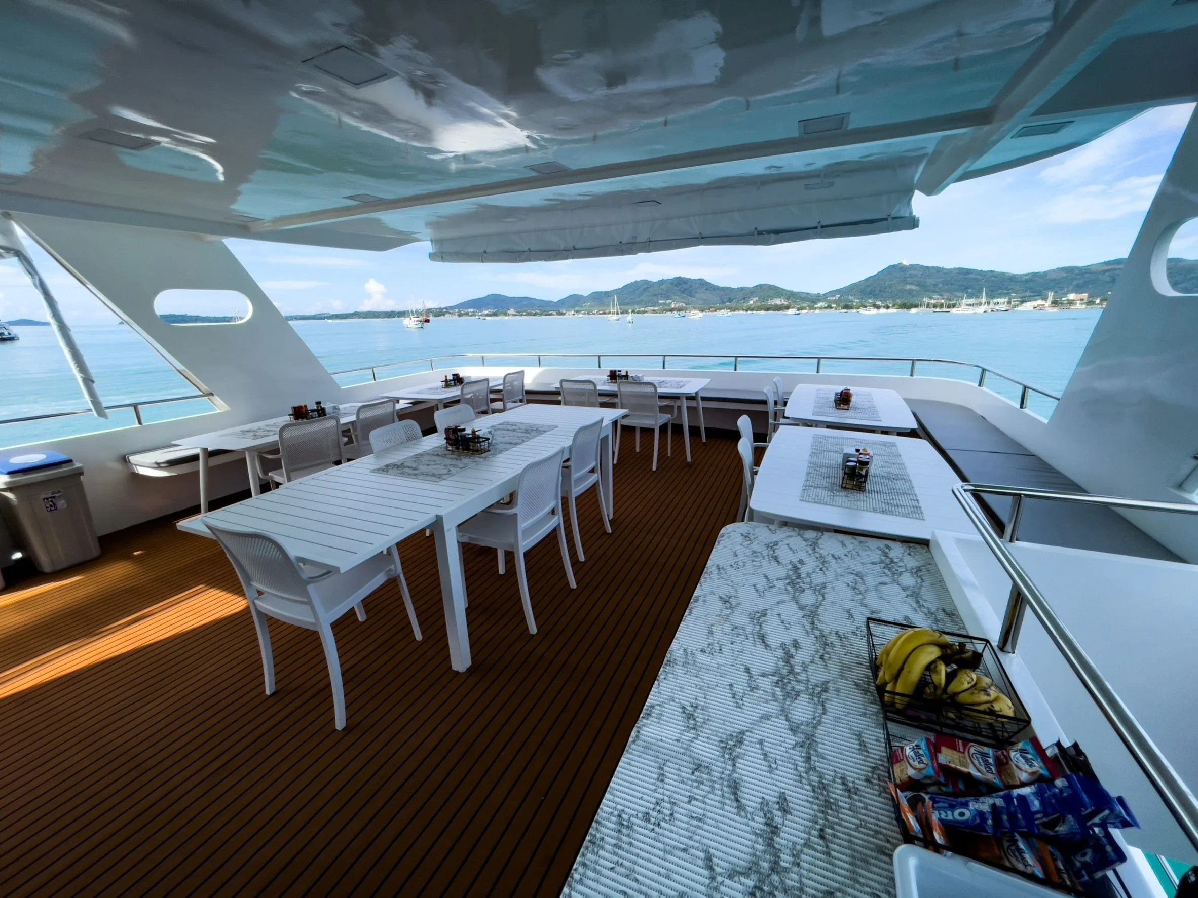 Outdoor dining area — laid tables and a panorama of the sea