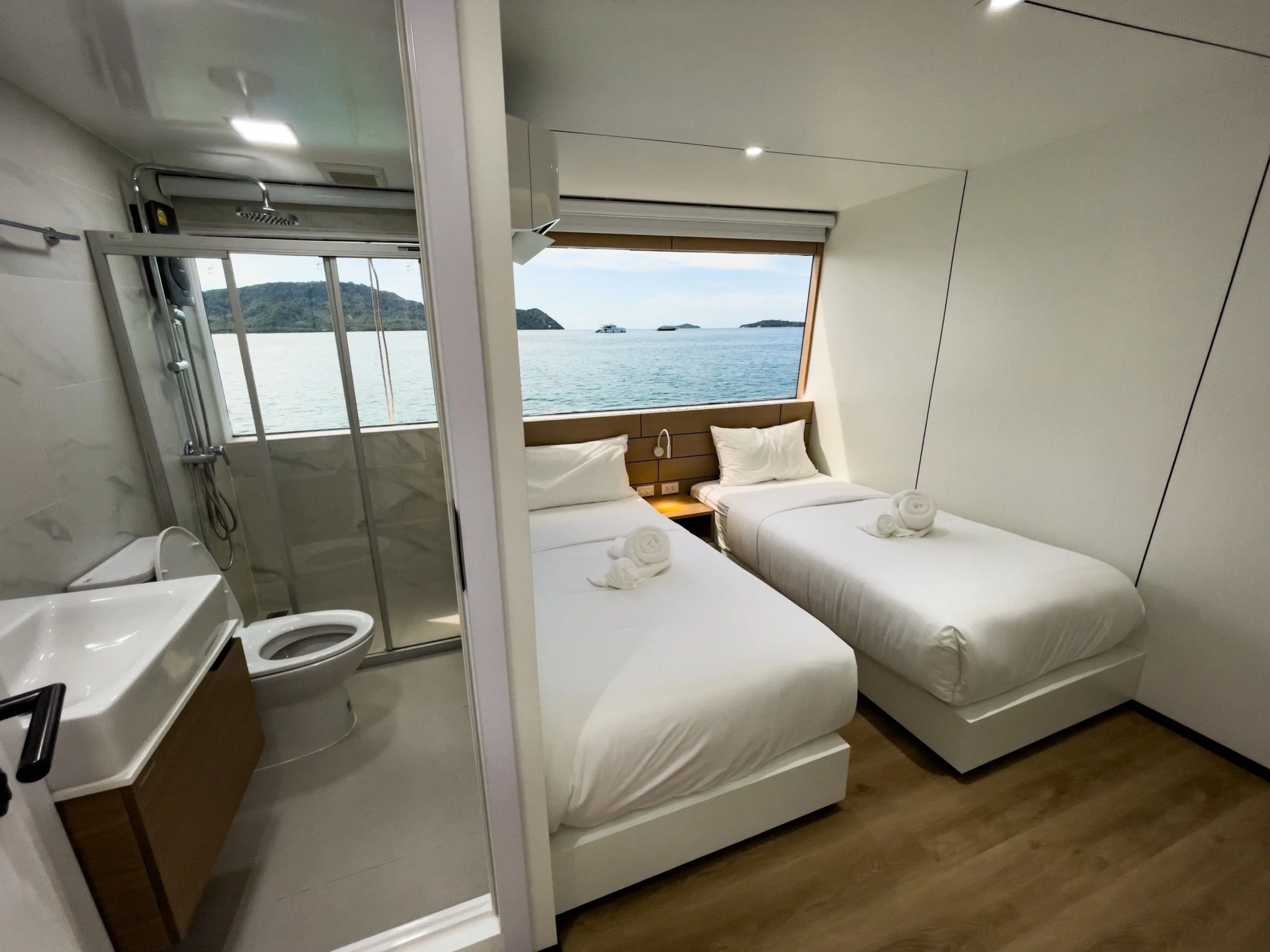 Twin cabin with a shower cubicle and a view of the sea