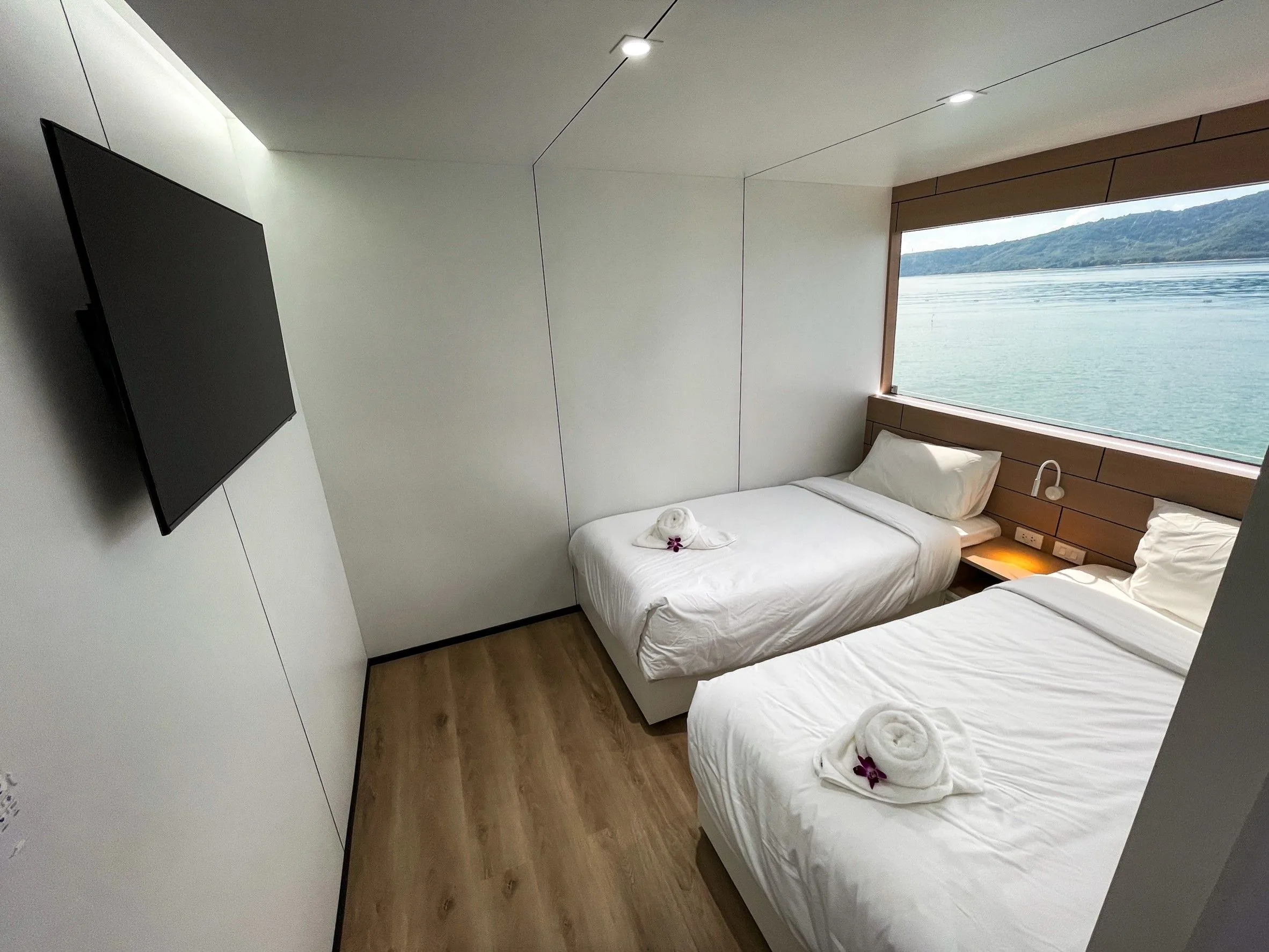 Separate beds, a TV and a window in a twin cabin