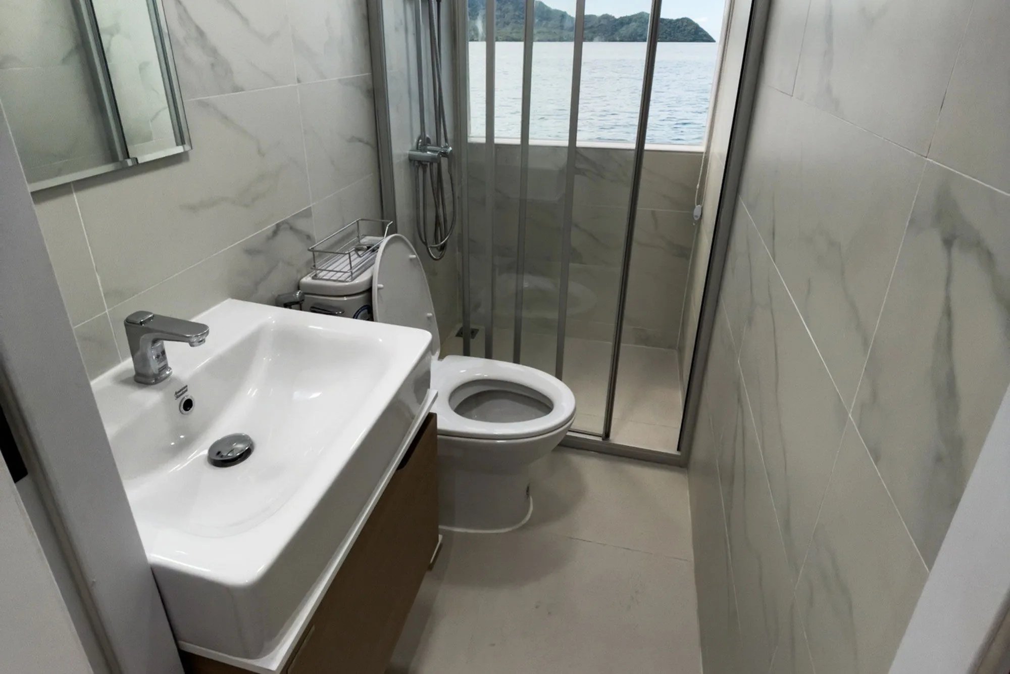 En-suite cabin bathroom — basin, shower cubicle and a window