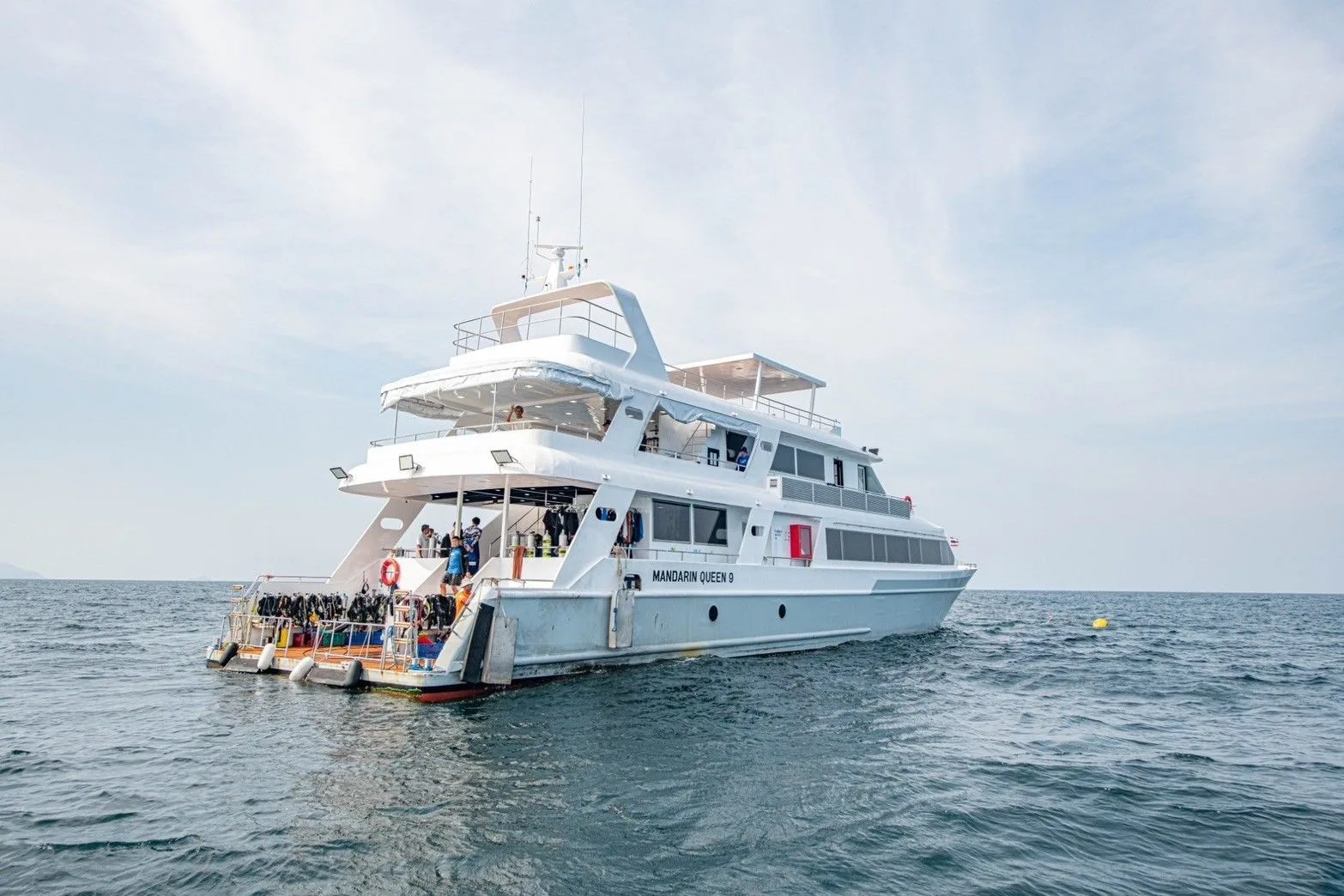 The stern of Mandarin Queen 9 — divers gathering on the platform before a dive