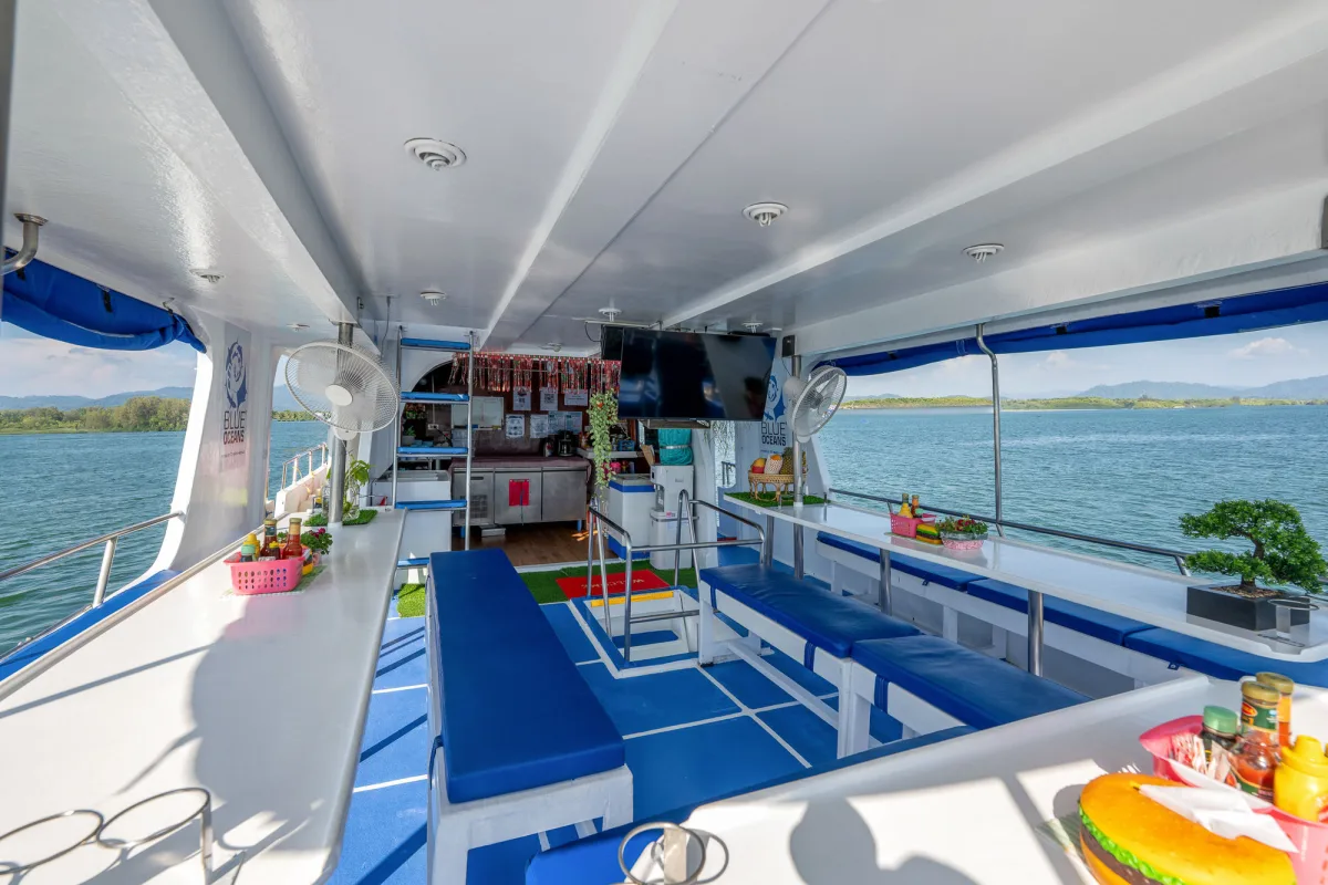Saloon of Manta Queen 2 with a television and long tables