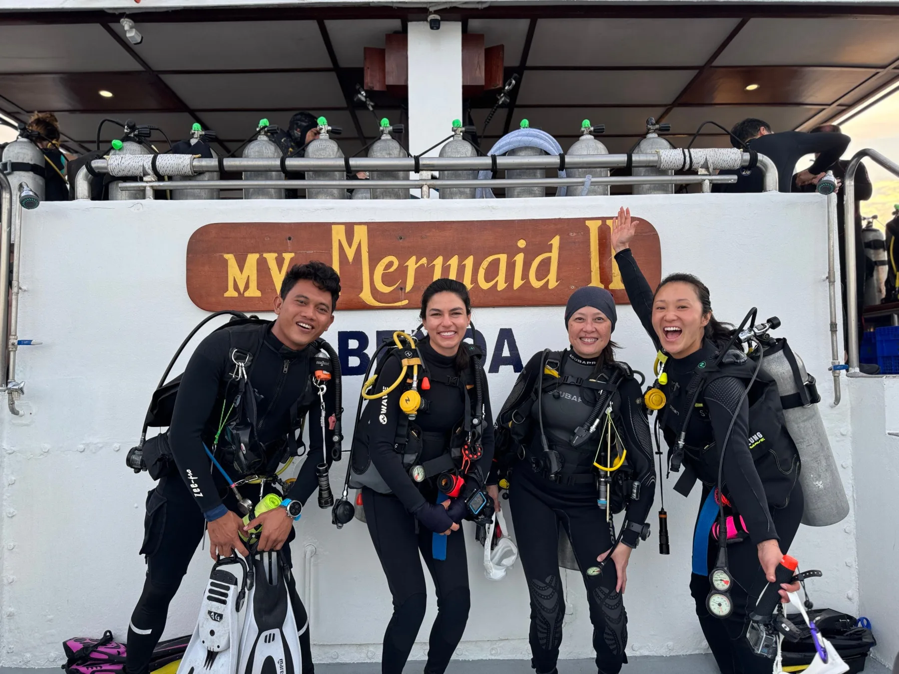 Дайверы в снаряжении под баннером MV Mermaid II