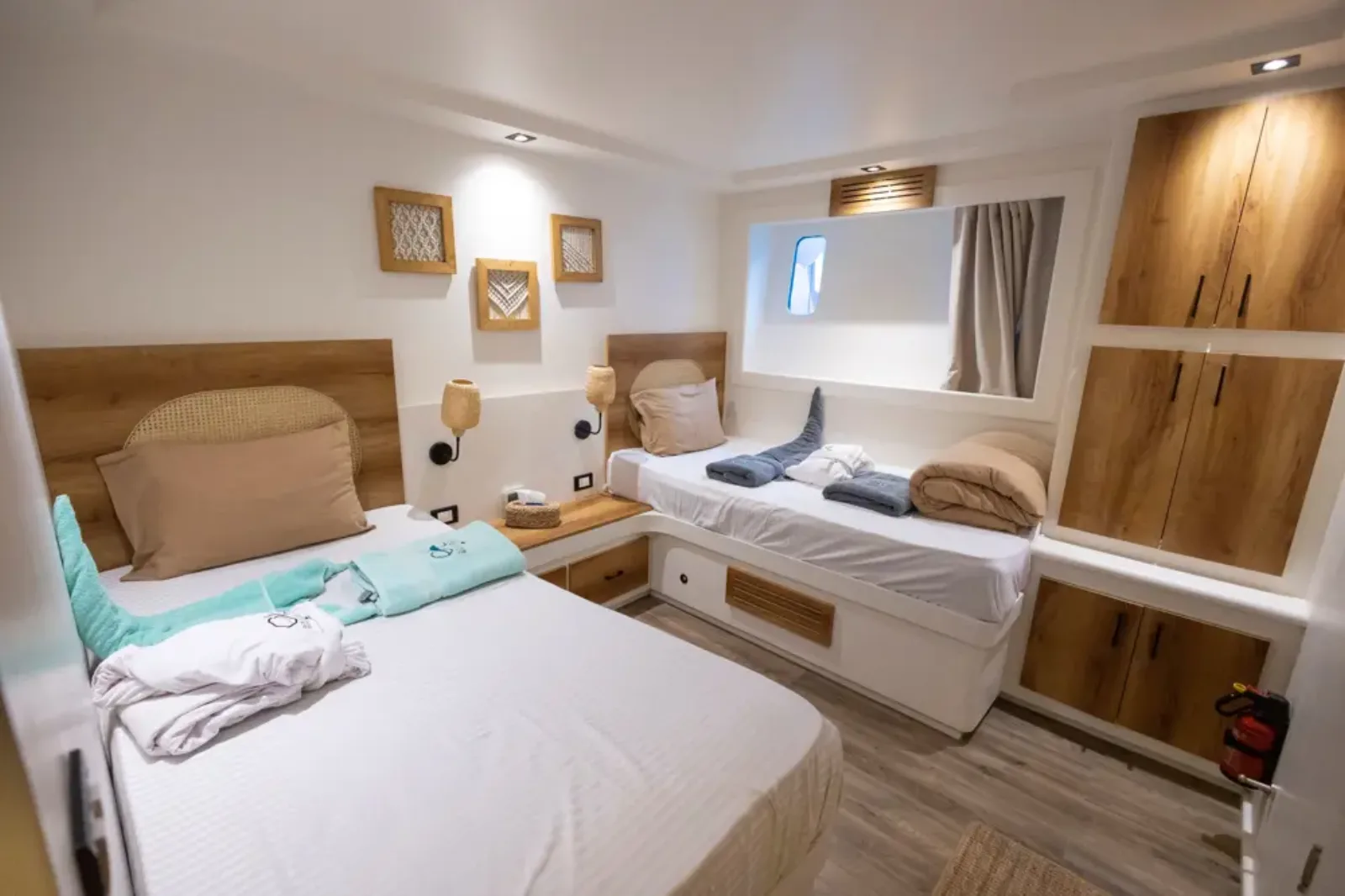 Twin cabin on the lower deck of Ocean Lovers — two single beds and a wooden wardrobe