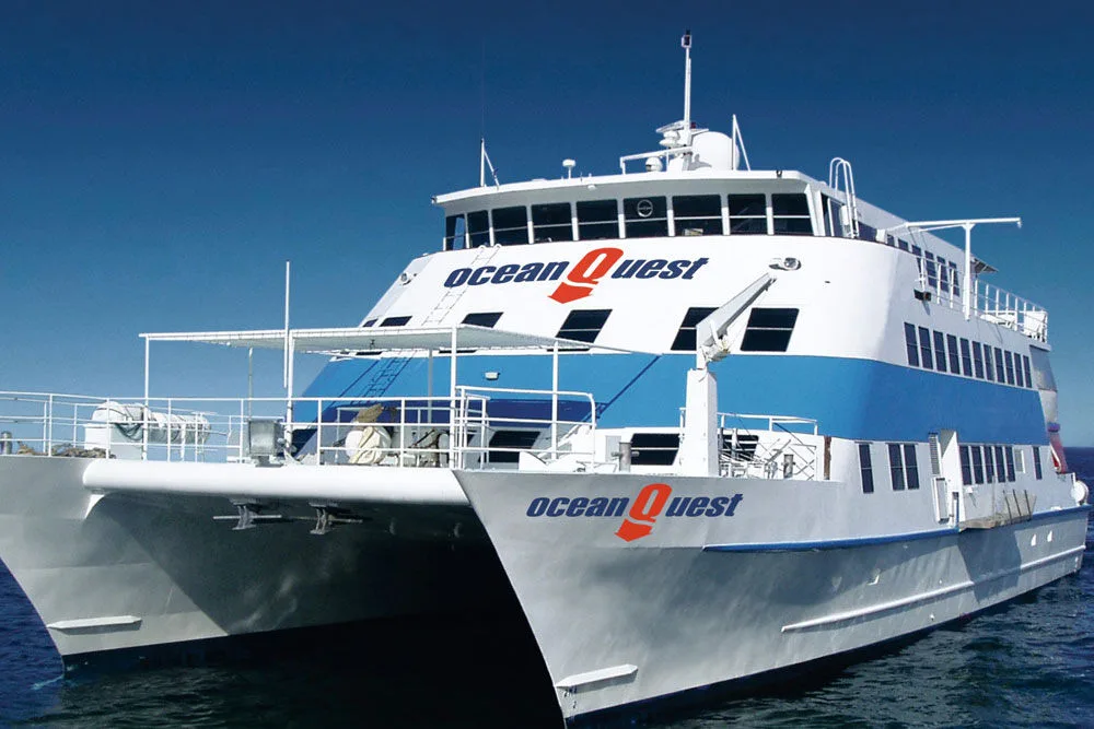 Bow of the Ocean Quest catamaran with the vessel name on the hull