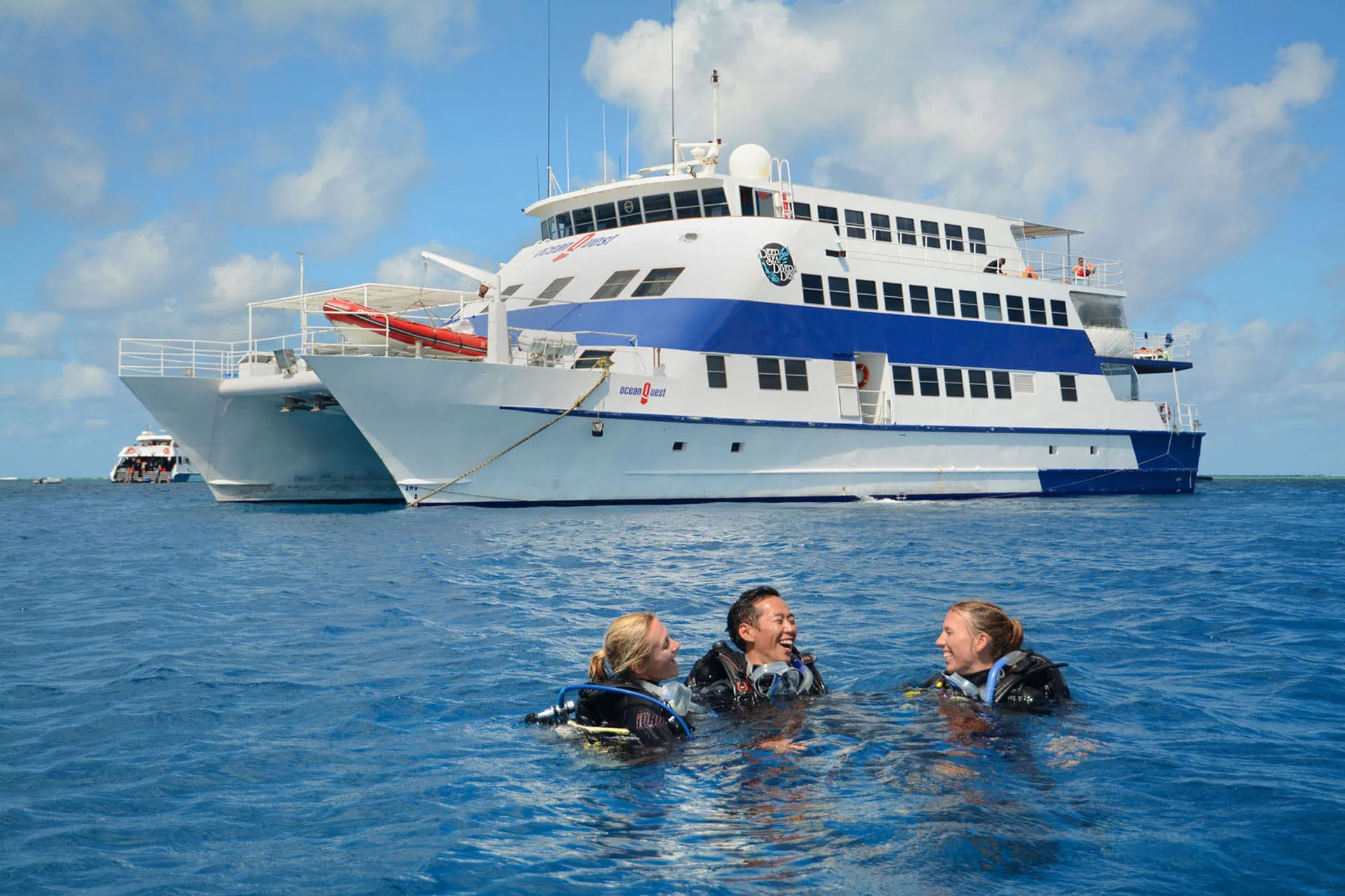 Divers on the surface beside the hull of Ocean Quest