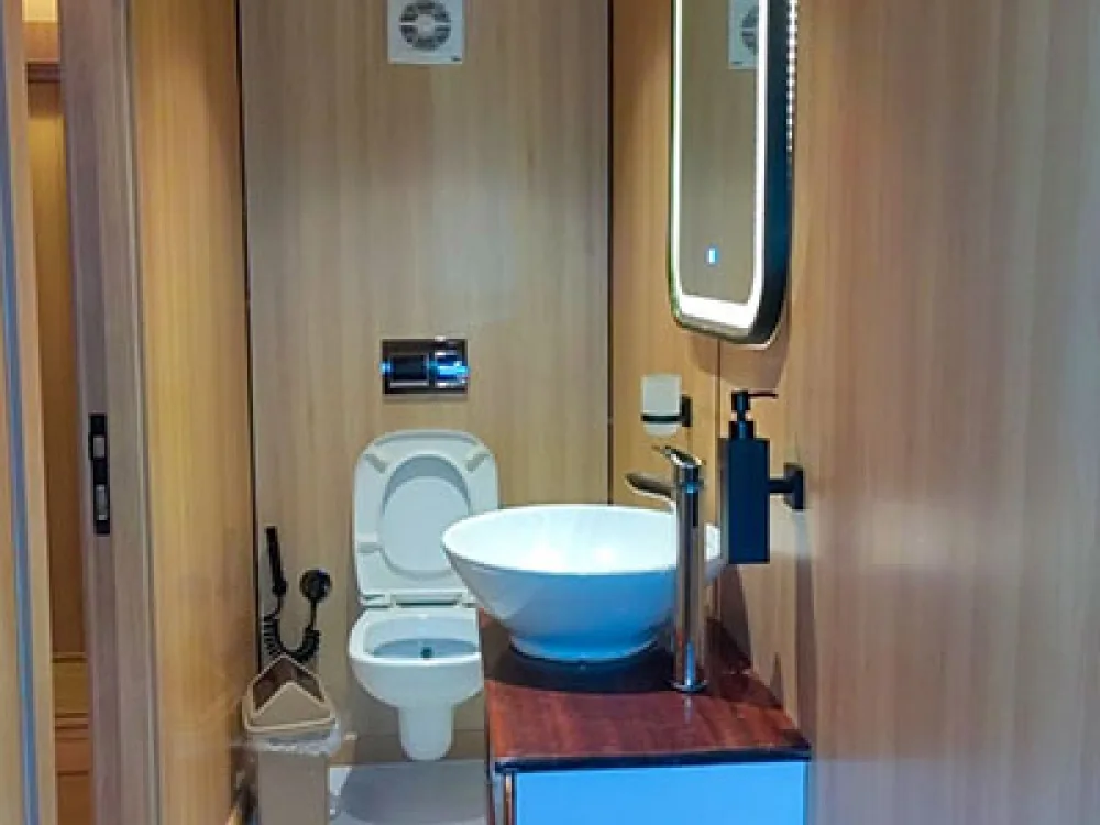 Odyssey cabin bathroom — basin, backlit mirror and toilet