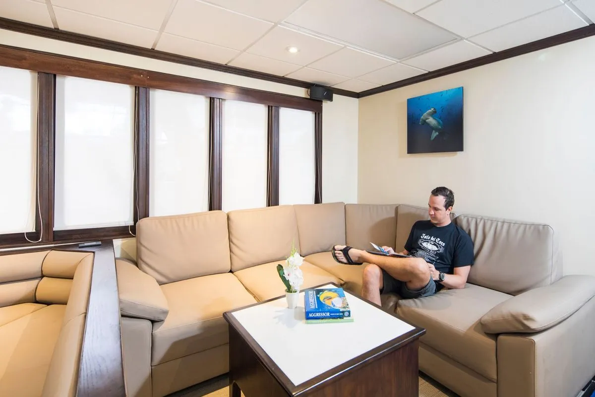 Salon of Okeanos Aggressor II with corner sofa and television